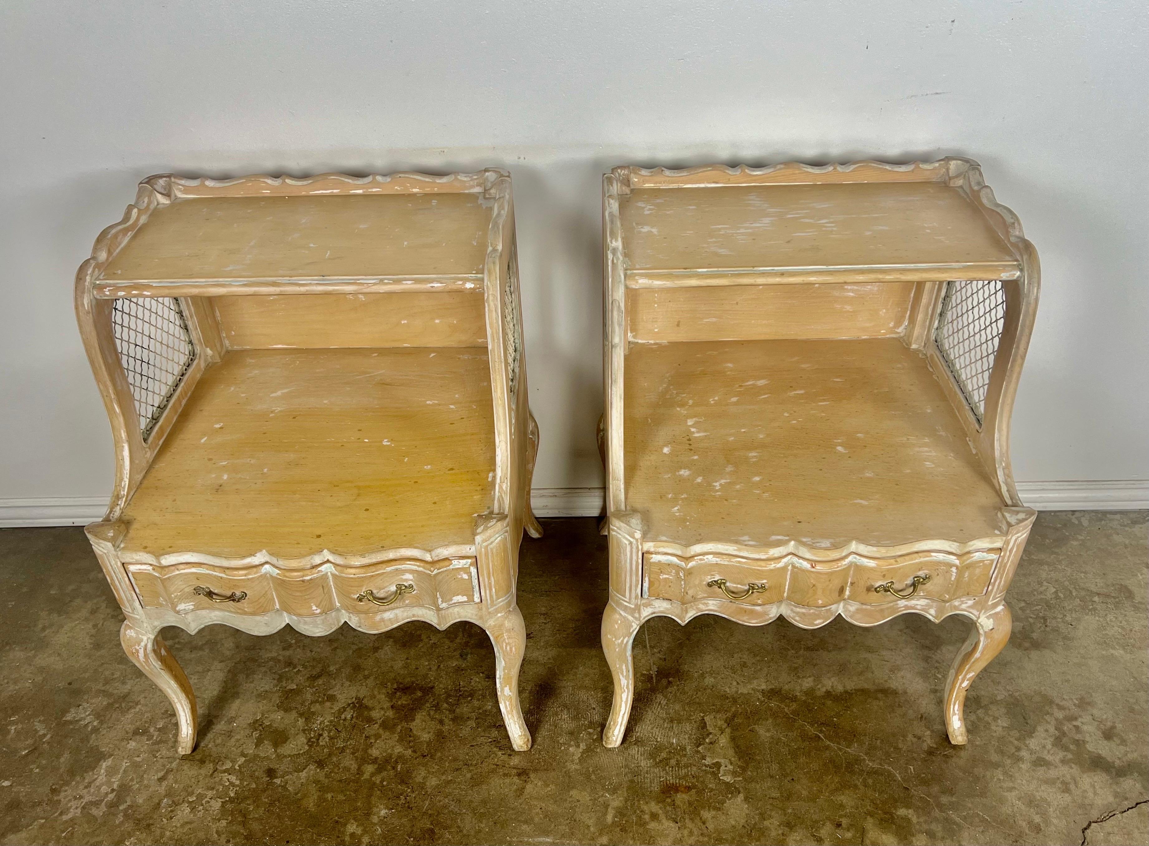 Pair of early 20th century two-tier side tables with drawers and iron grate insets on sides. The tables stand on four cabriole legs.  Weathered finish with paint remnants left throughout.  Great dove tailing on drawers.  Original brass hardware.
