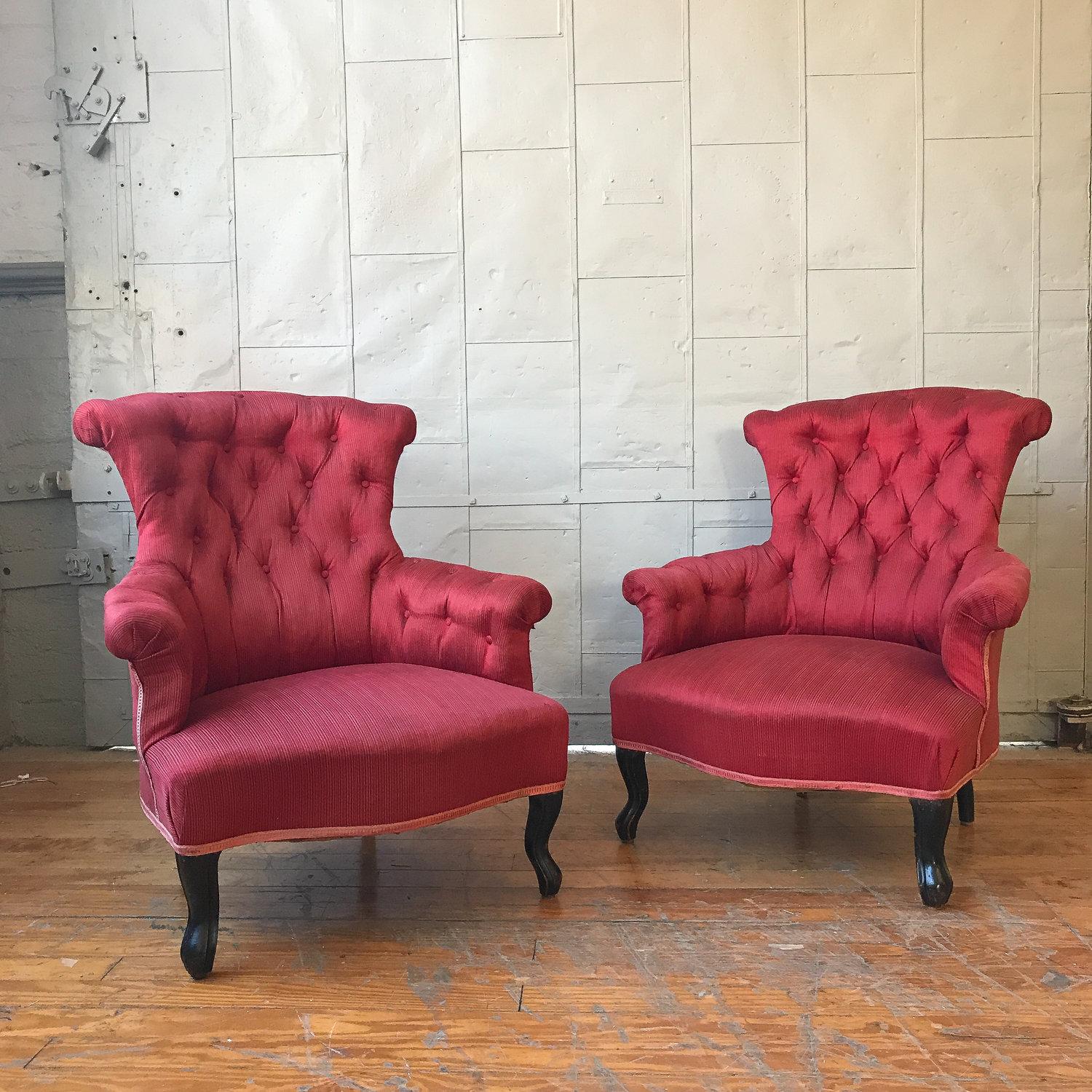 A striking pair of 19th century French Napoleon III armchairs. Skillfully crafted and luxuriously upholstered in a vivid red fabric, these chairs make the perfect accent in any interior. With their eye-catching tufted backs and sturdy structure,