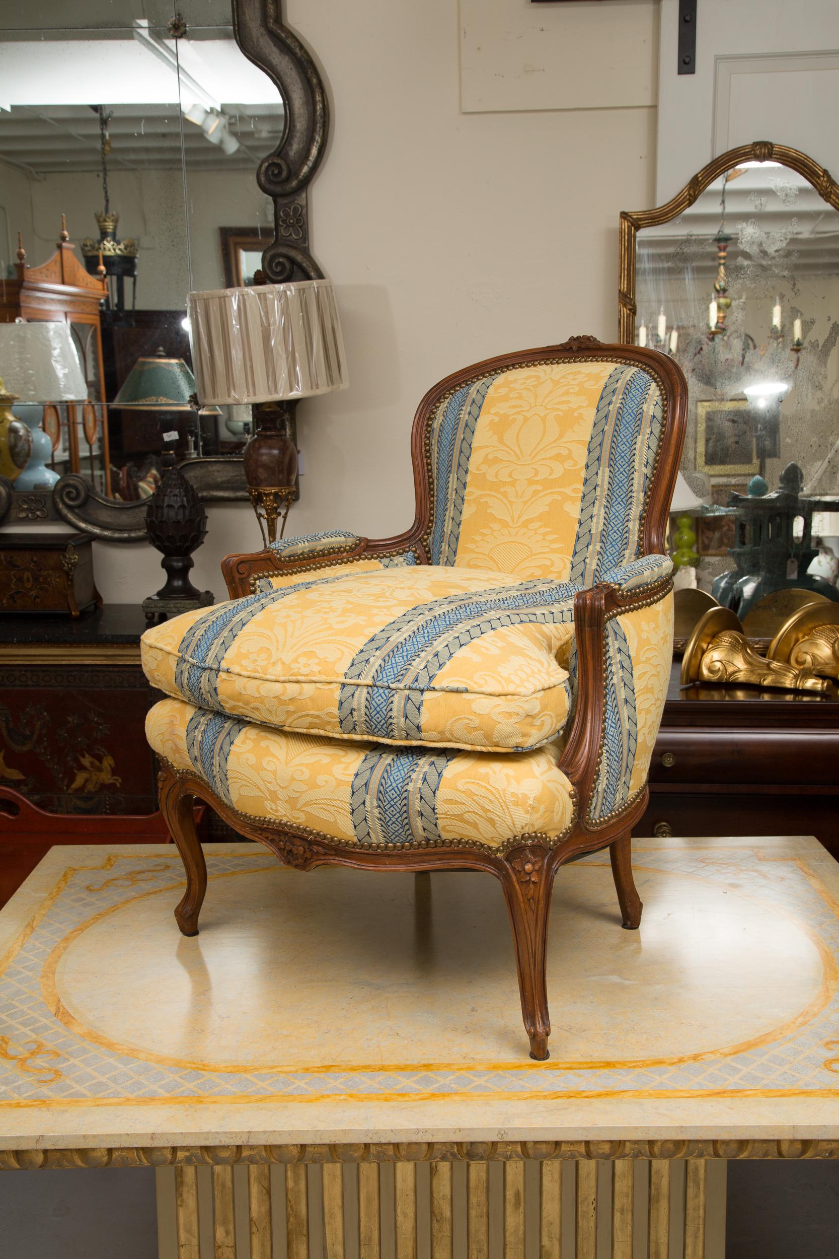 These well proportioned French Bergeres are upholstered with a hand carved walnut frame. Mid-20th century.