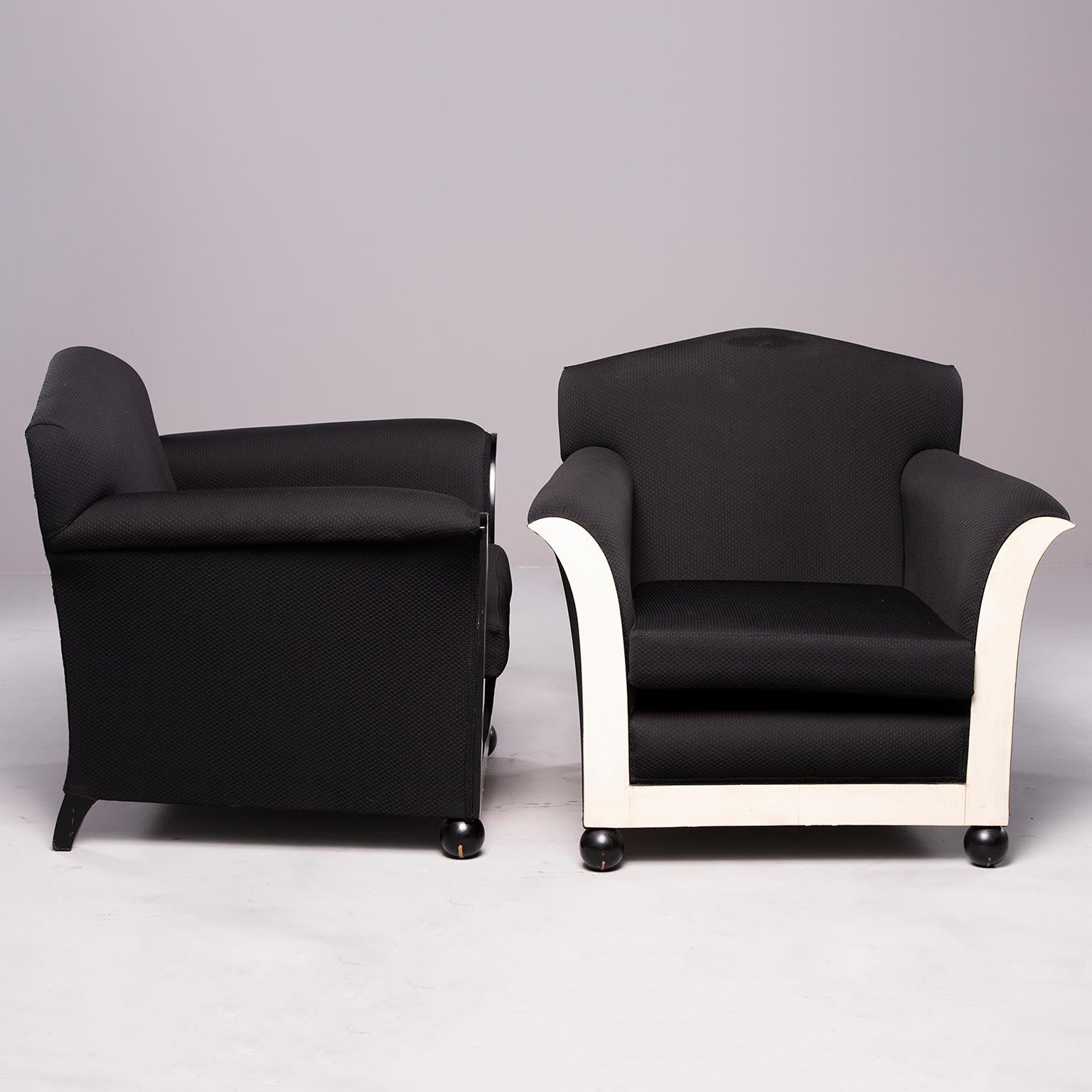Pair of French club chairs with black upholstery, circa 1930s. Front of chairs feature ball feet and flared arms with contrasting off-white vellum inserts. Sold and priced as a pair. 

Measures: Arm height 23.25” 
Seat height 14.5”
Seat depth