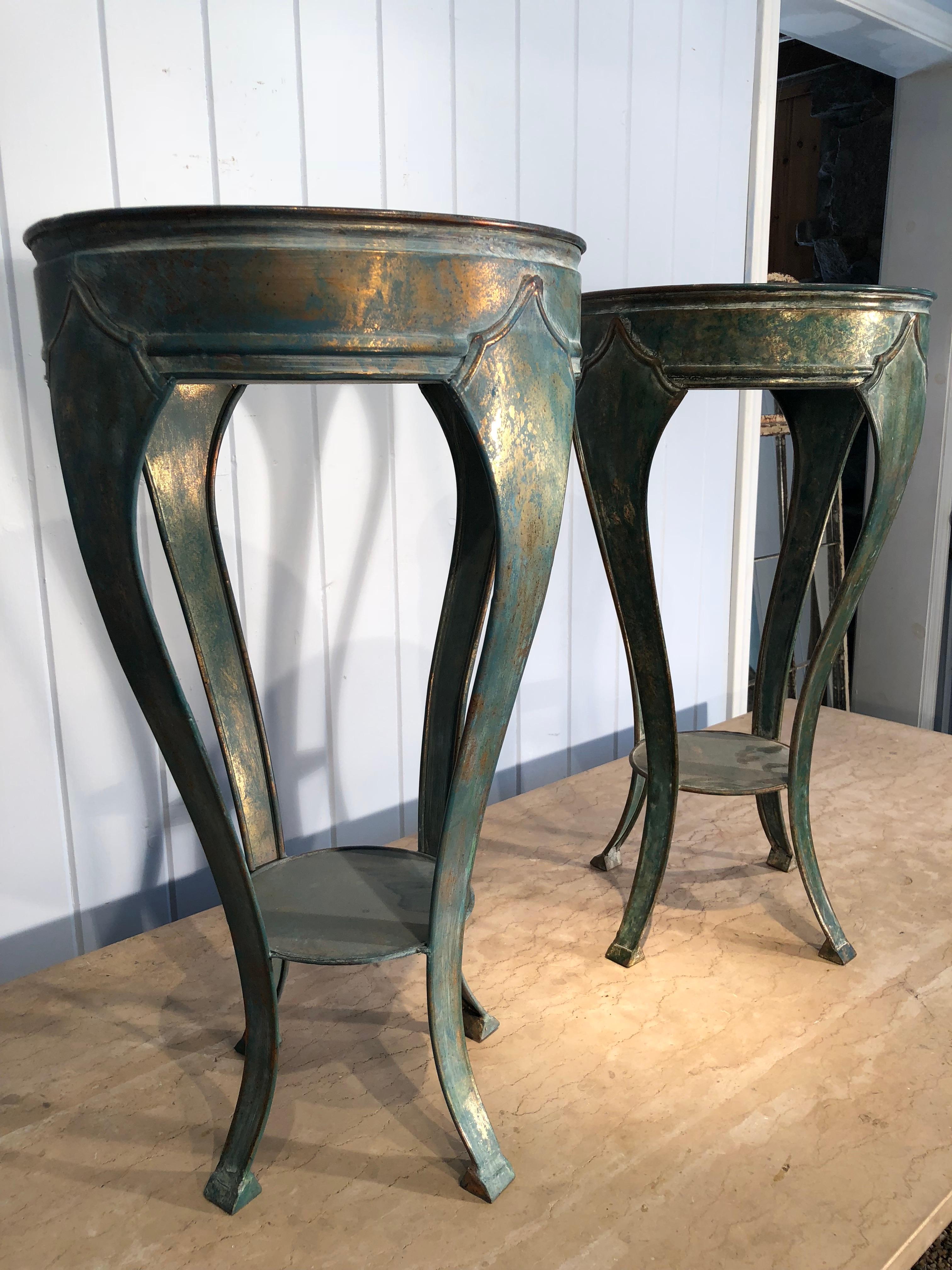 This is an unusual pair of lightweight brass plant stand tables that has been faux-finished in a lovely verdigris color that allows the brass to glint through. Perfect as side tables with glass or marble tops, or plant them up for a decorative