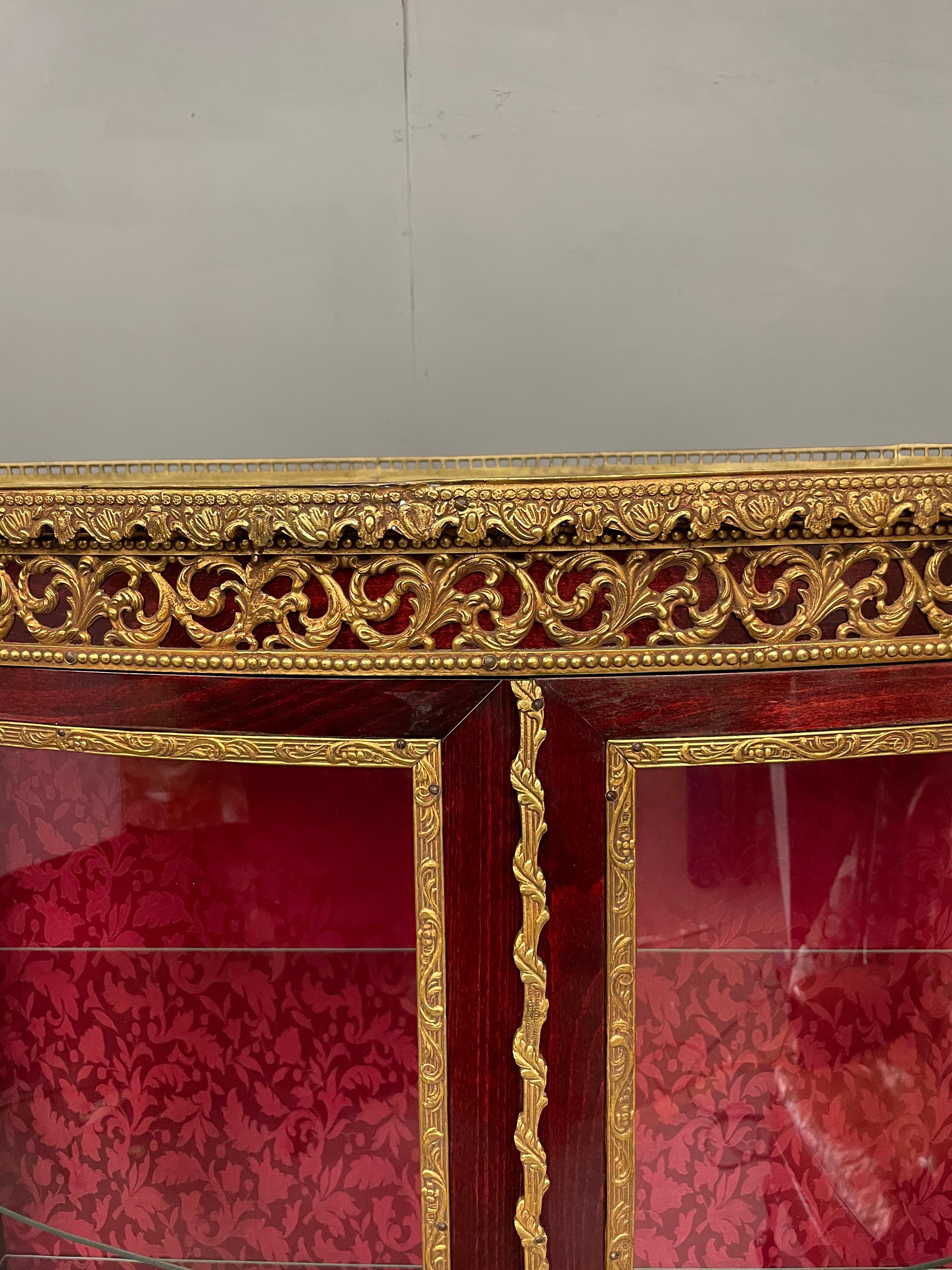 Pair of French Vernis Martin style display cabinets .
The cabinets are in very good condition with good quality brass ormolu mounts through out .
They each have two bow front glass doors with serpentine sides the interior has two glass shelves