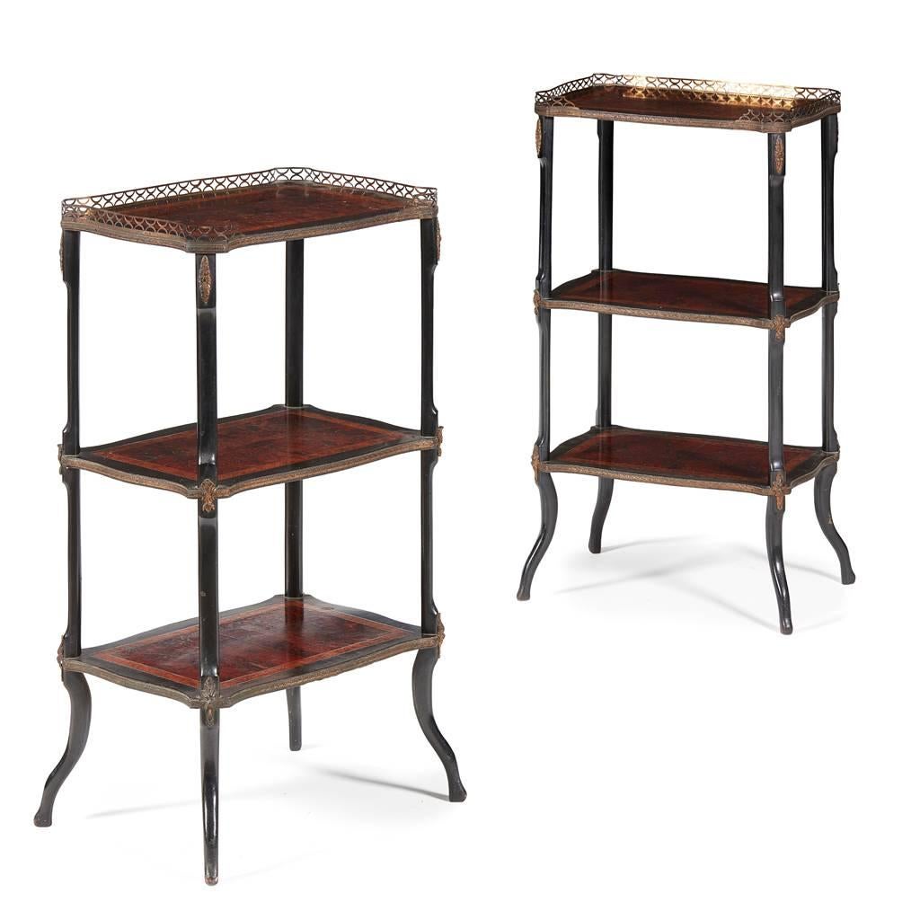 Pair of French three-tier etageres, circa 1880. With shaped top and three quarter wrap around brass gallery above foliate banding decoration. The tops of each tier or shelf are in amboyna, and boxwood, ebony and burr elm banding, and there are oval