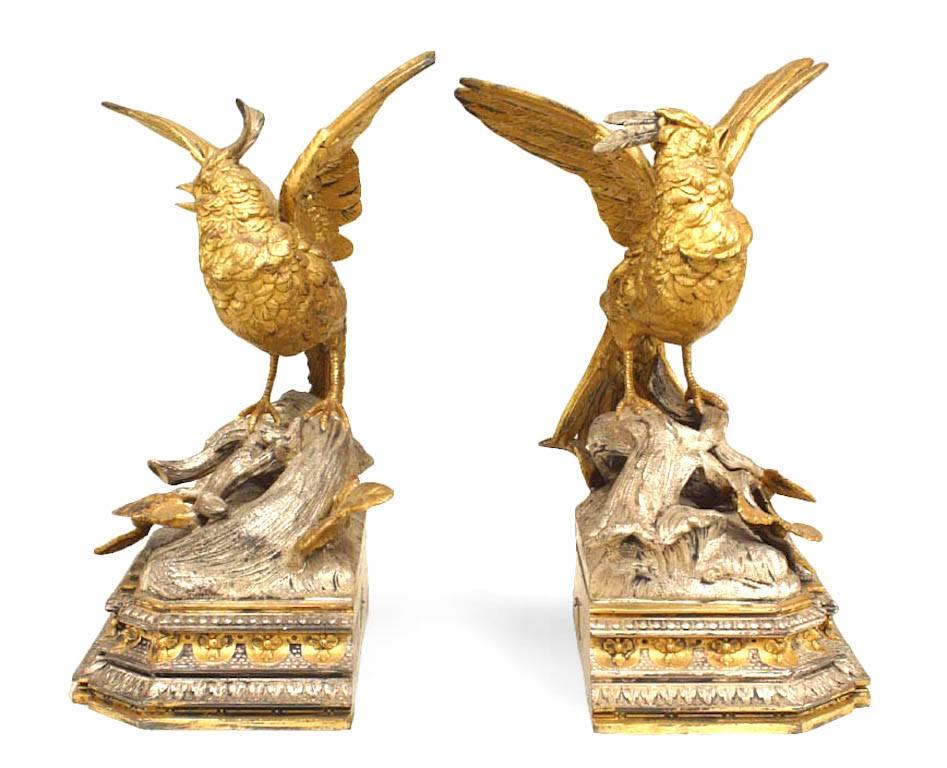 Pair of French Victorian silver and gilt plated metal birds standing among branches on a tiered rectangular base

