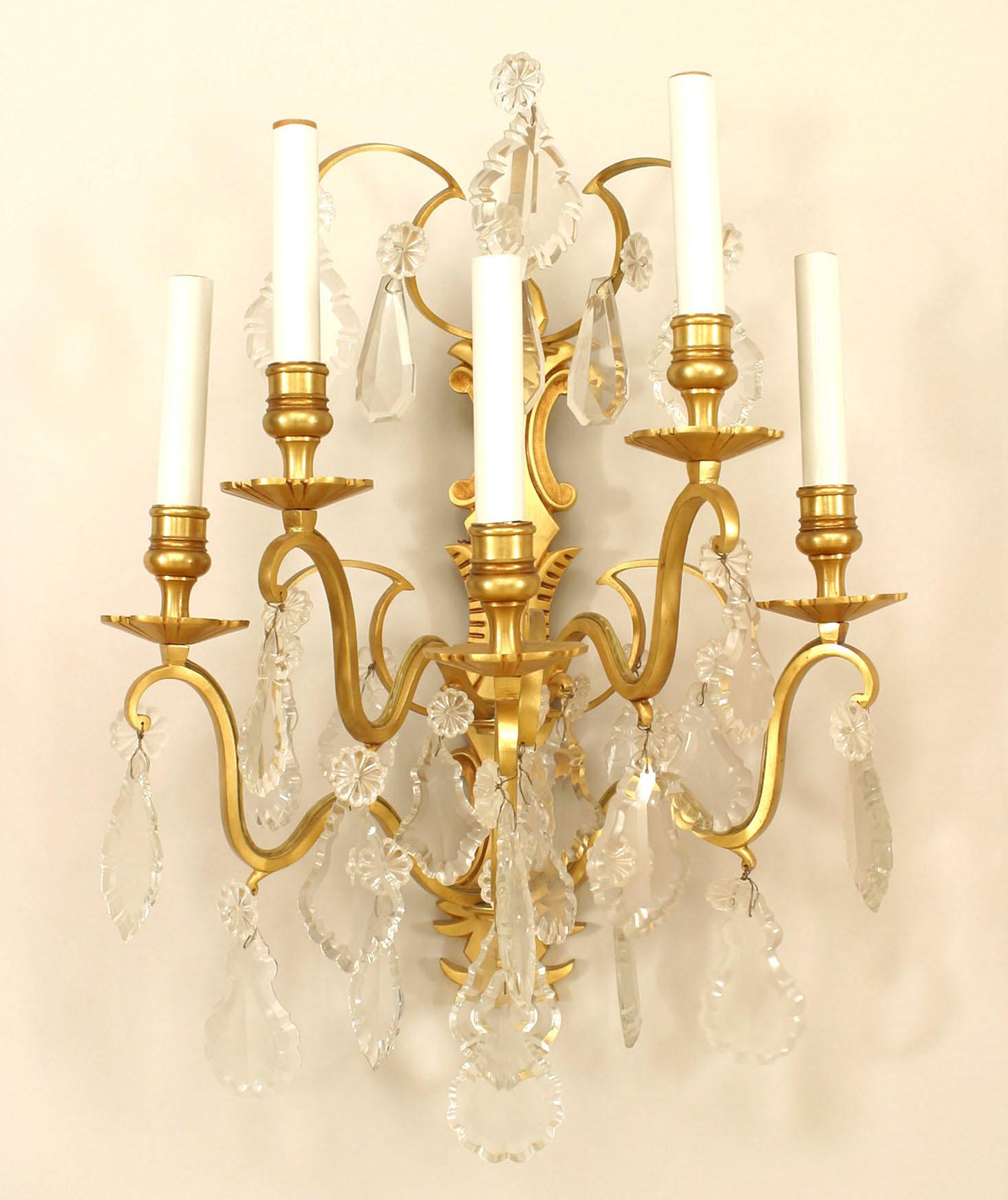 Pair of French Victorian-style (20th Century) gilt bronze and crystal wall sconces with five arms emanating from a horizontal backplate with shaped crystal drops. (PRICED AS Pair)
