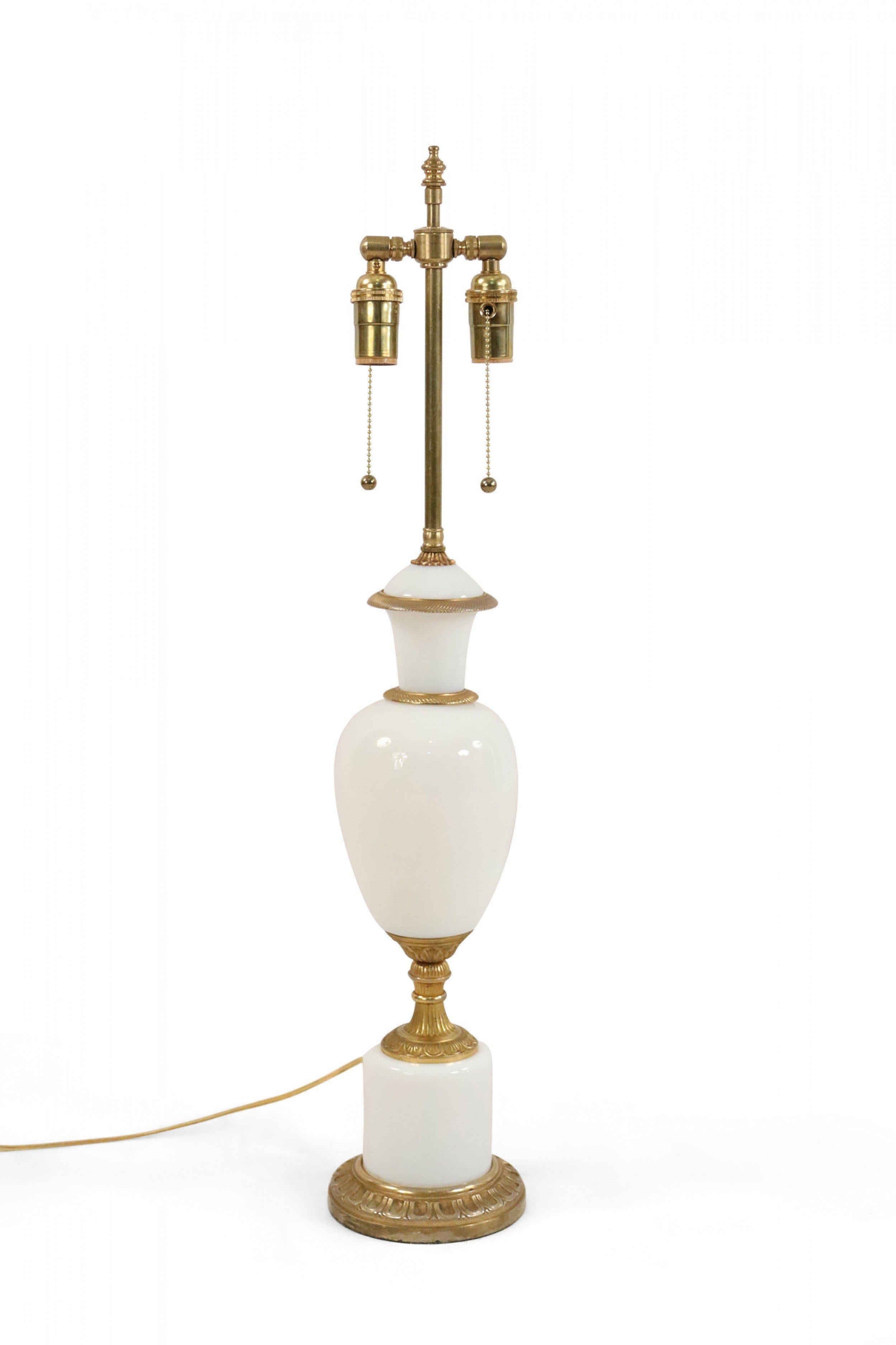Pair of French Victorian-style white opaline glass table lamps with vase-shaped forms and brass details on a circular base.