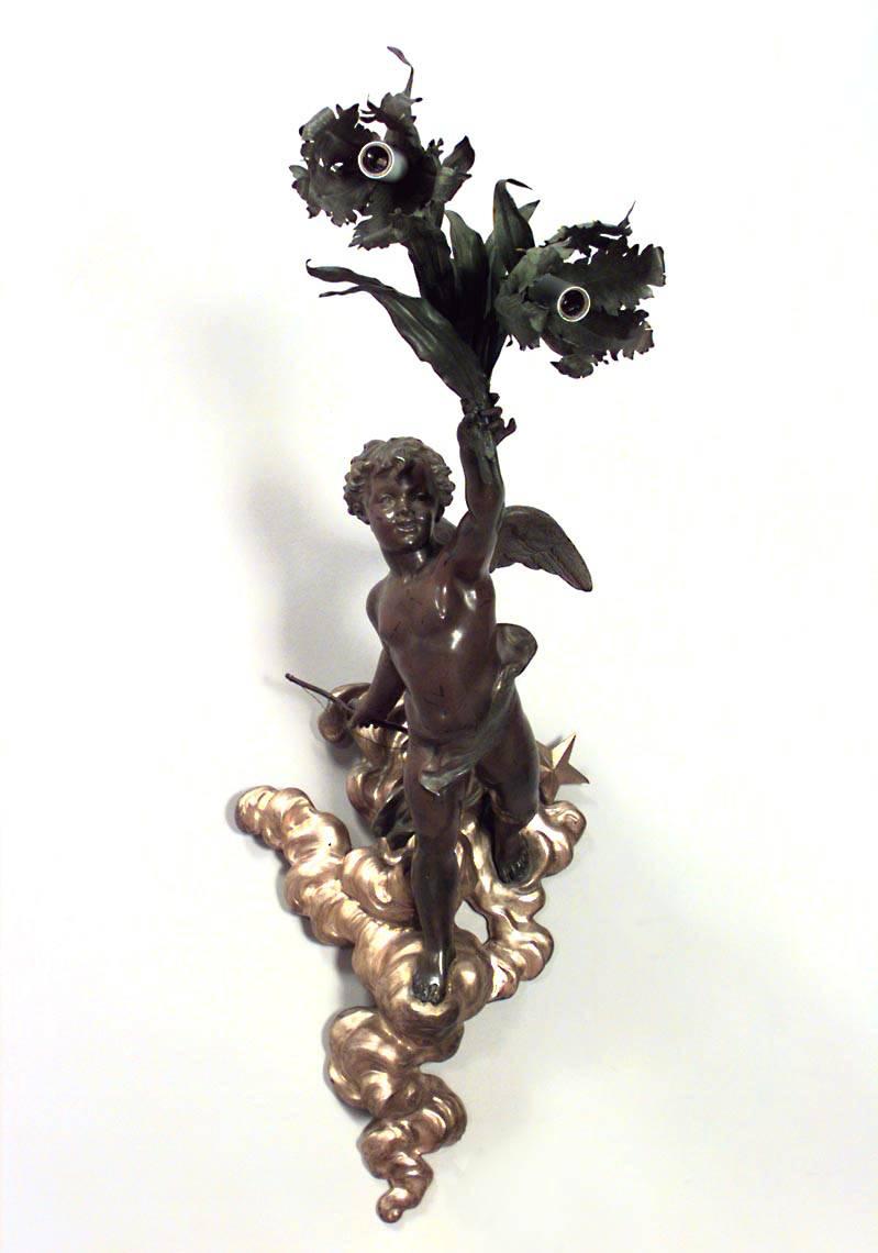 Pair of French Victorian patinated metal wall sconces with cupid figures holding two floral design lights supported on a bronze dore cloud. (PRICED AS Pair)
