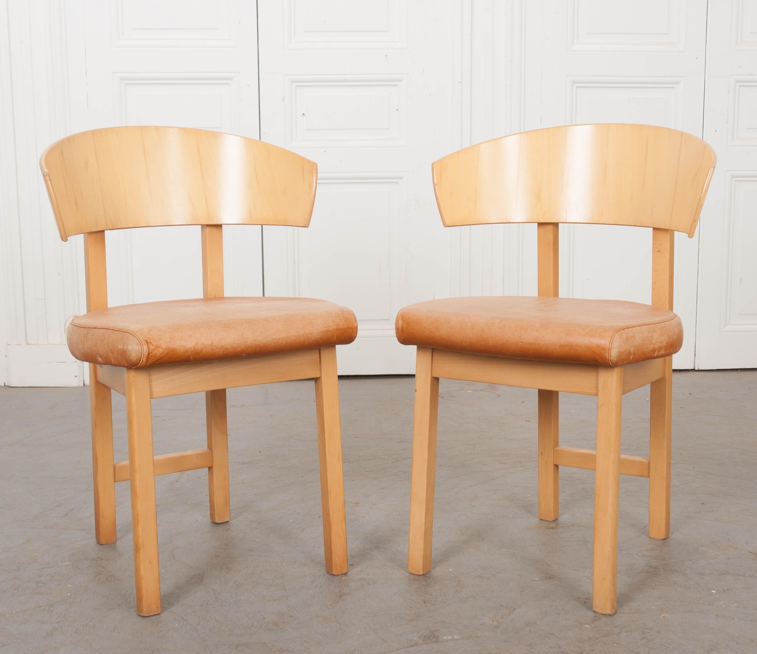 This fantastic pair of vintage Art Deco-style blonde wood side chairs are from France. The low, open chair backs and thin, linear legs, give these chairs a geometric profile indicative of the era. They would add a fun eclectic vibe to any room!