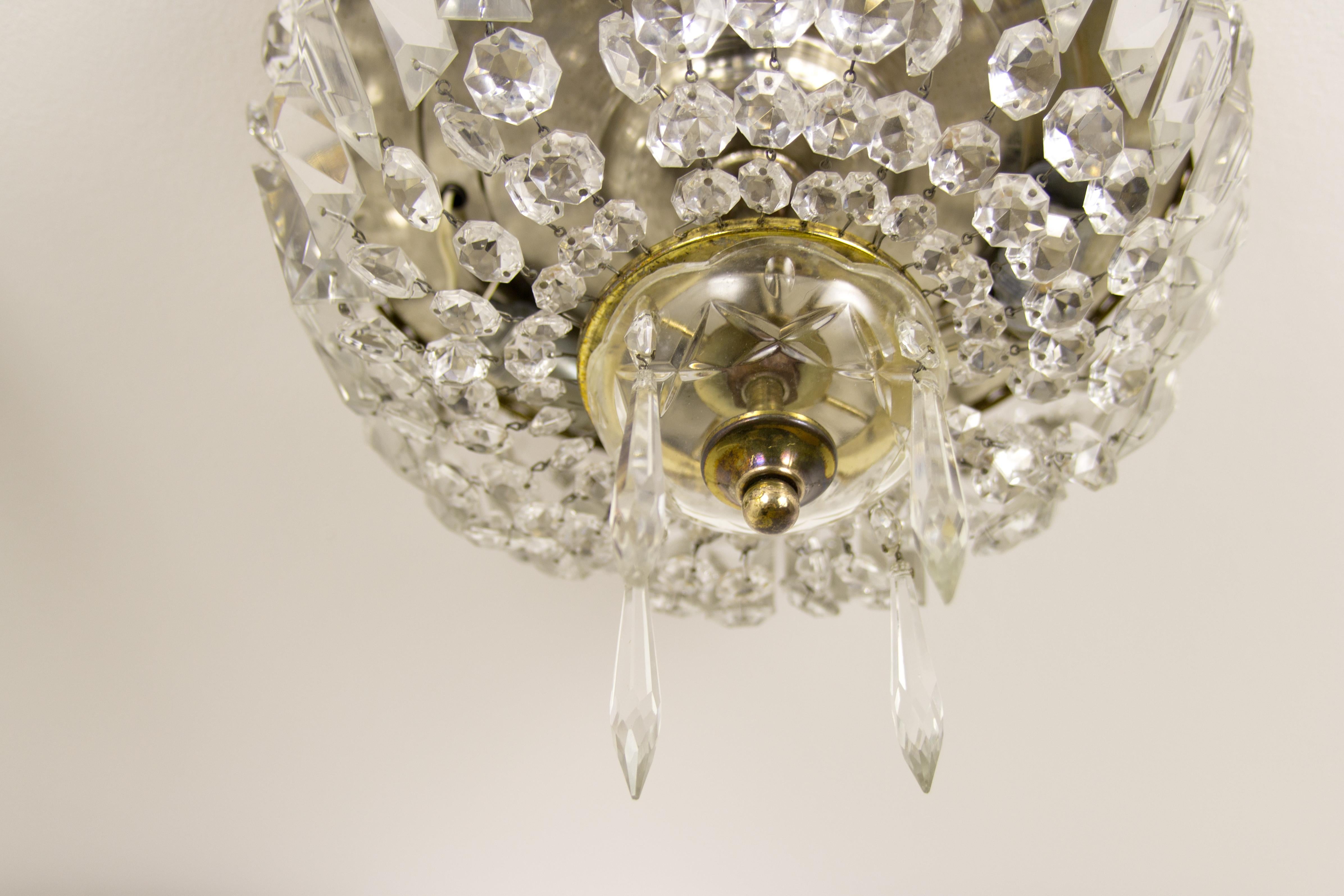 A pair of classic crystal glass and brass ceiling fixtures or flush mounts. Brass fitting decorated with glass diamonds, prism plates, and icicles.
The crystal shades will beautifully sparkle when the light is on. These elegant three-light fixtures