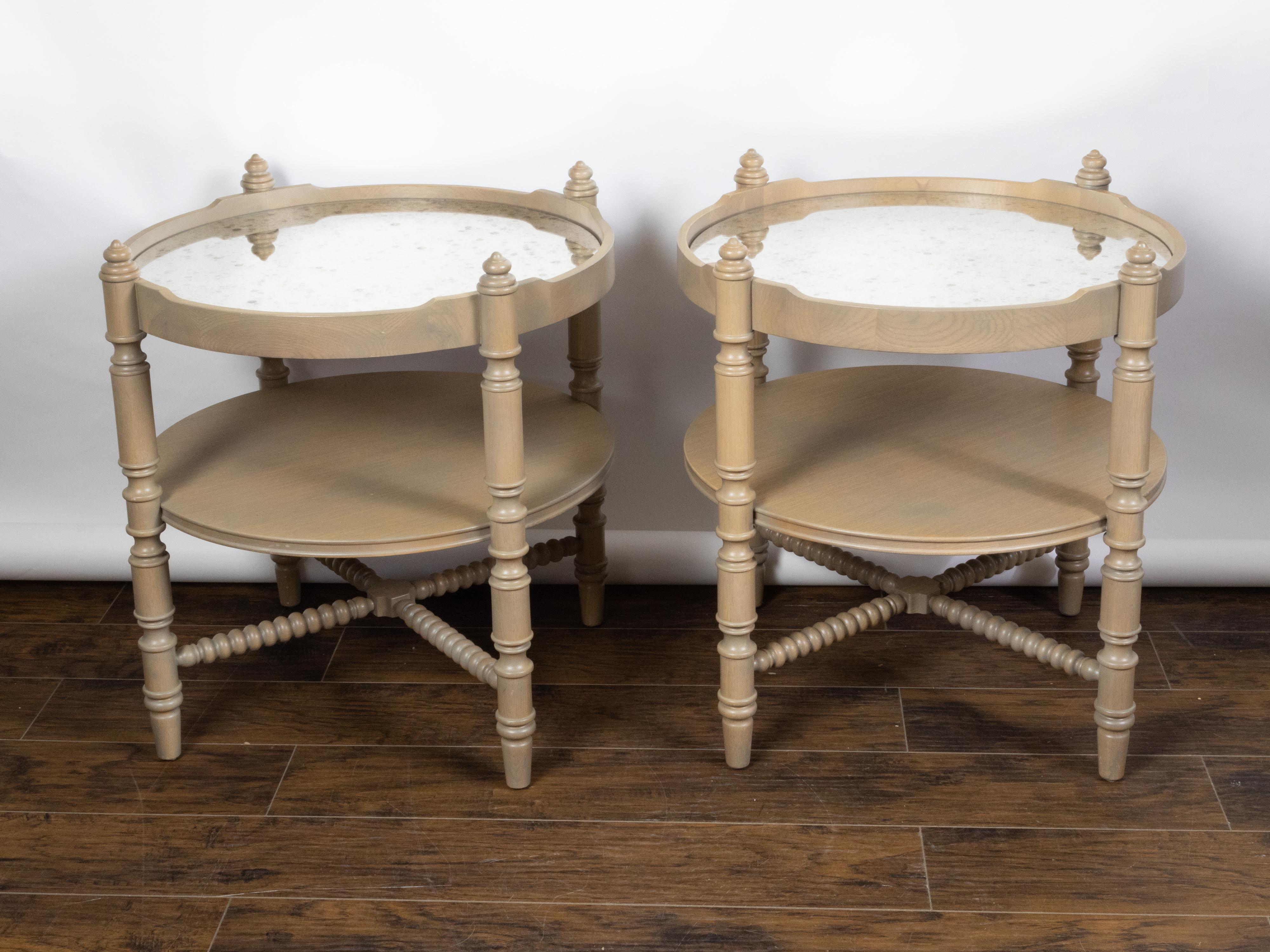 A pair of French vintage oak side tables from the mid 20th century, with mirrored tops and turned legs. Created in France during the second half of the 20th century, each of this pair of side tables features a circular mirrored top secured within