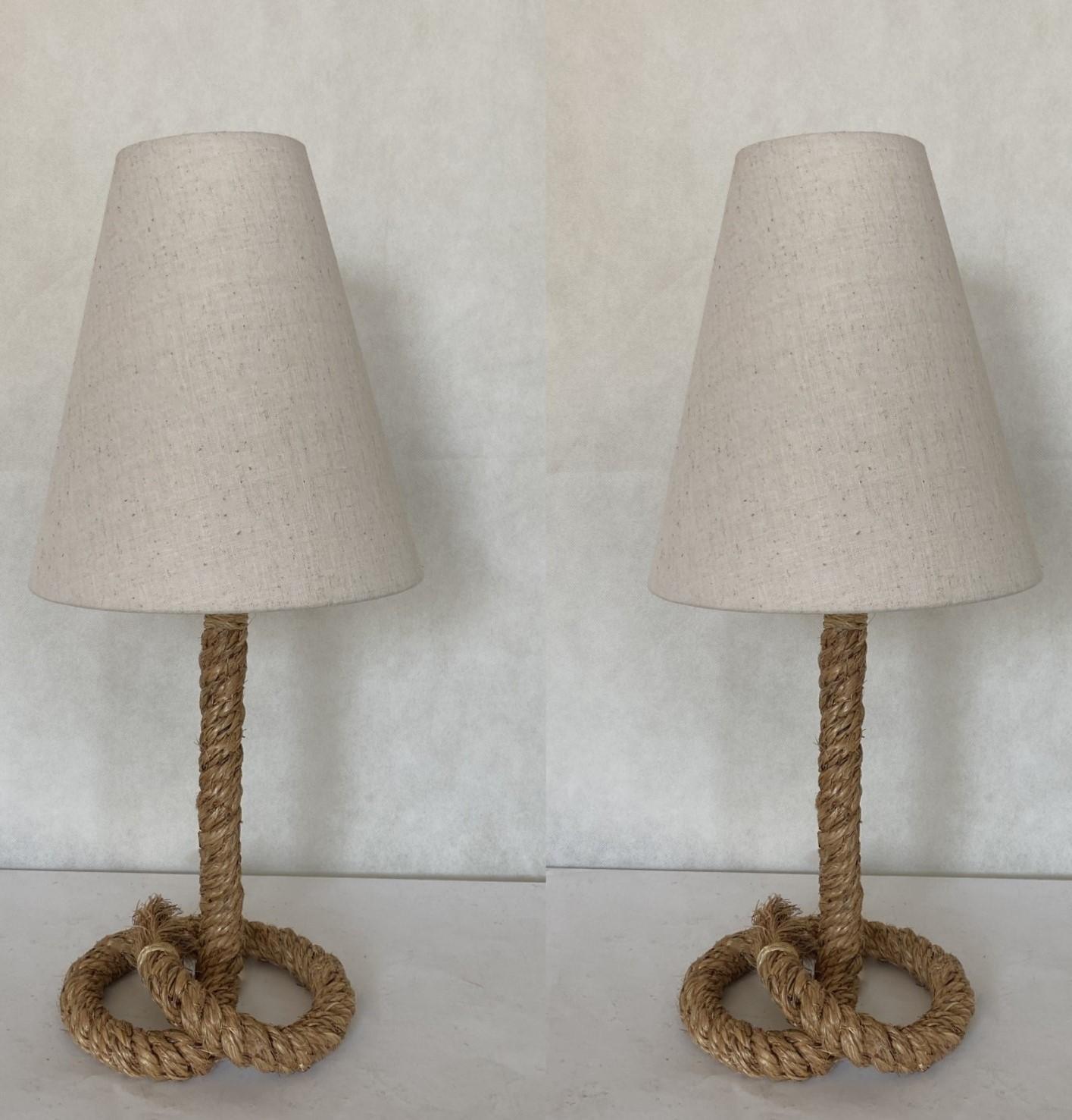 A pair of lovely hand-crafted rope table lamps with linen shades in the style of Audoux Minet, France, 1990s. Both lamps in very good condition, no damages, rewired, new shades. Each lamp tkes one E27 light bulb. Switch to turn on and off on the