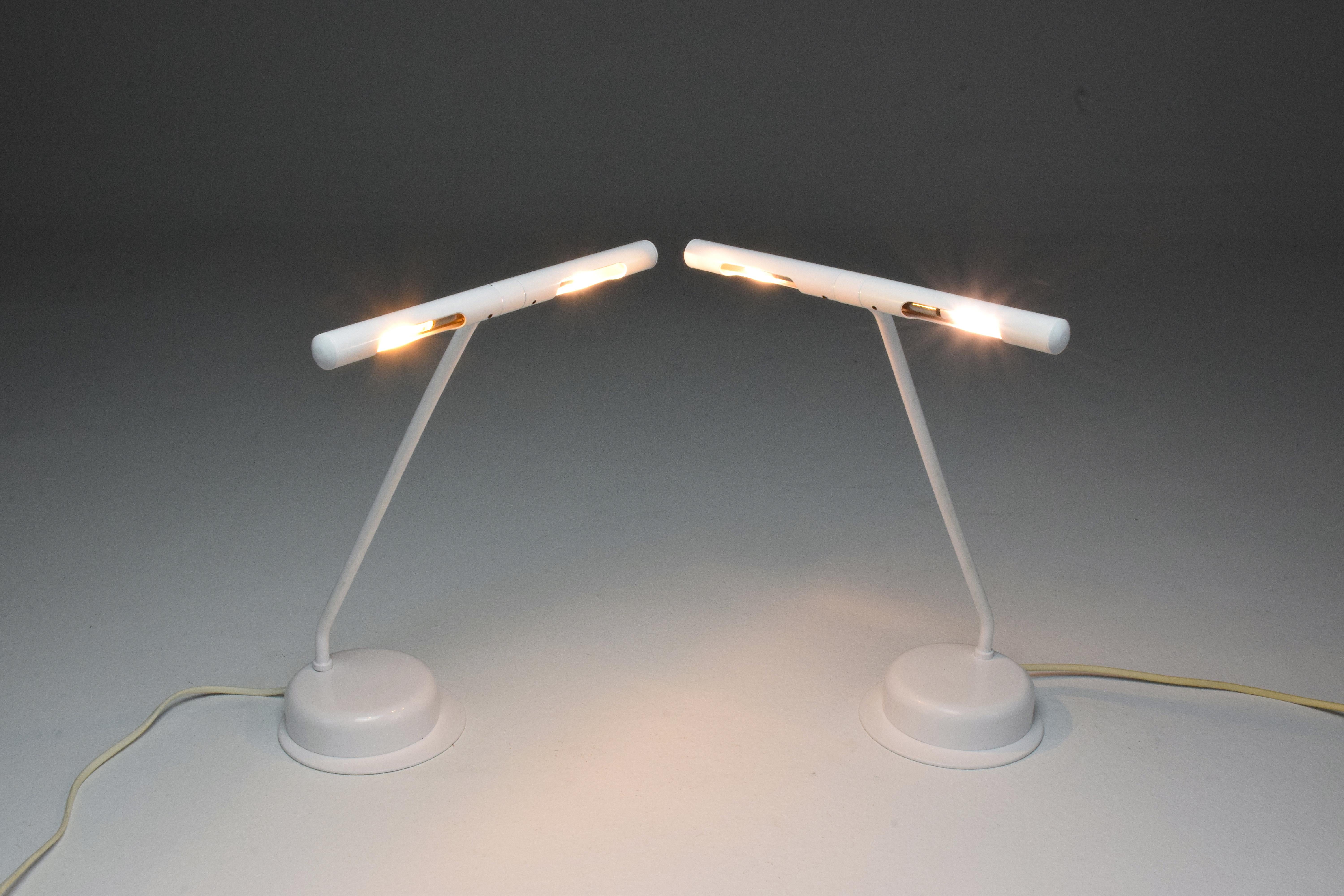 A pair of French 20th century vintage table or desk metal lamps designed with a rotatable shade, re-lacquered in their original white finish. One is very slightly lower than the other. The switch has been replaced but the wiring is original.
