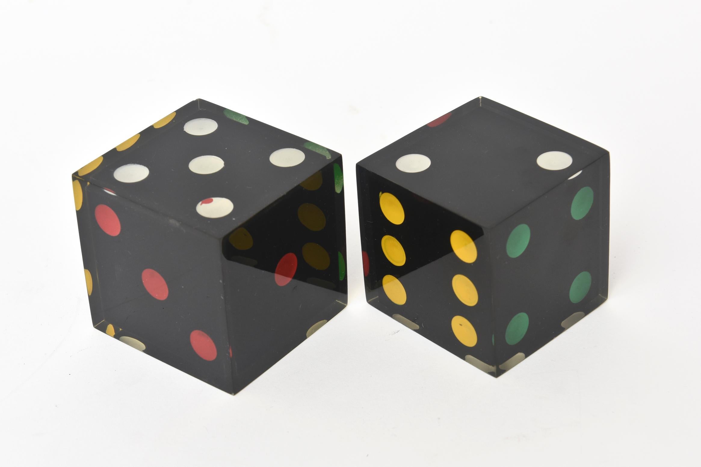 This most unusual and rare pair of French vintage square sculptural lucite large dice have a strong palate of color in primary colors of red, green, white, yellow set against black. They have been polished to the best they can be. These are hard to