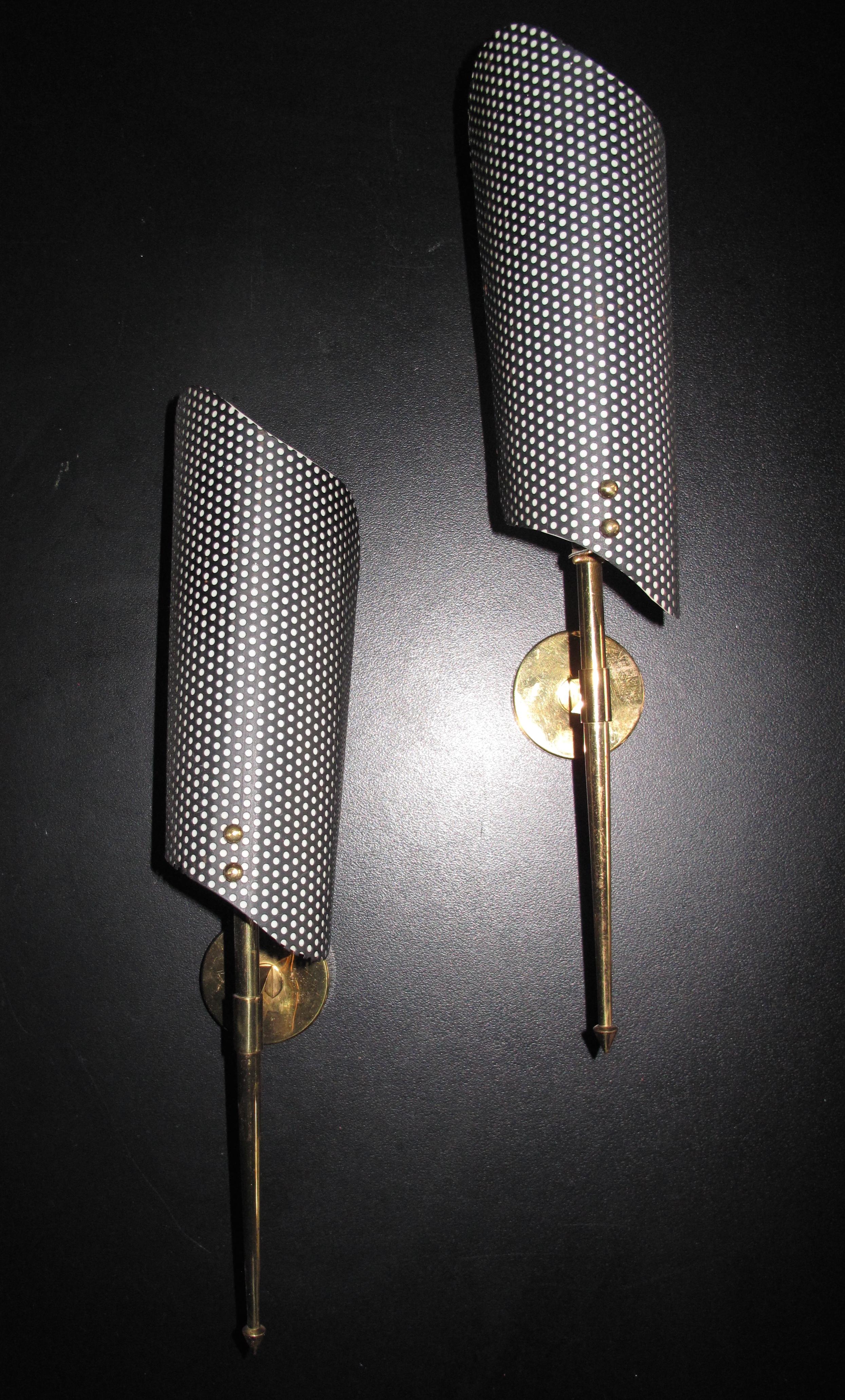 In the manner of Biny, each light with an enameled and perforated metal shade, with brass mounts and fittings.

 





 