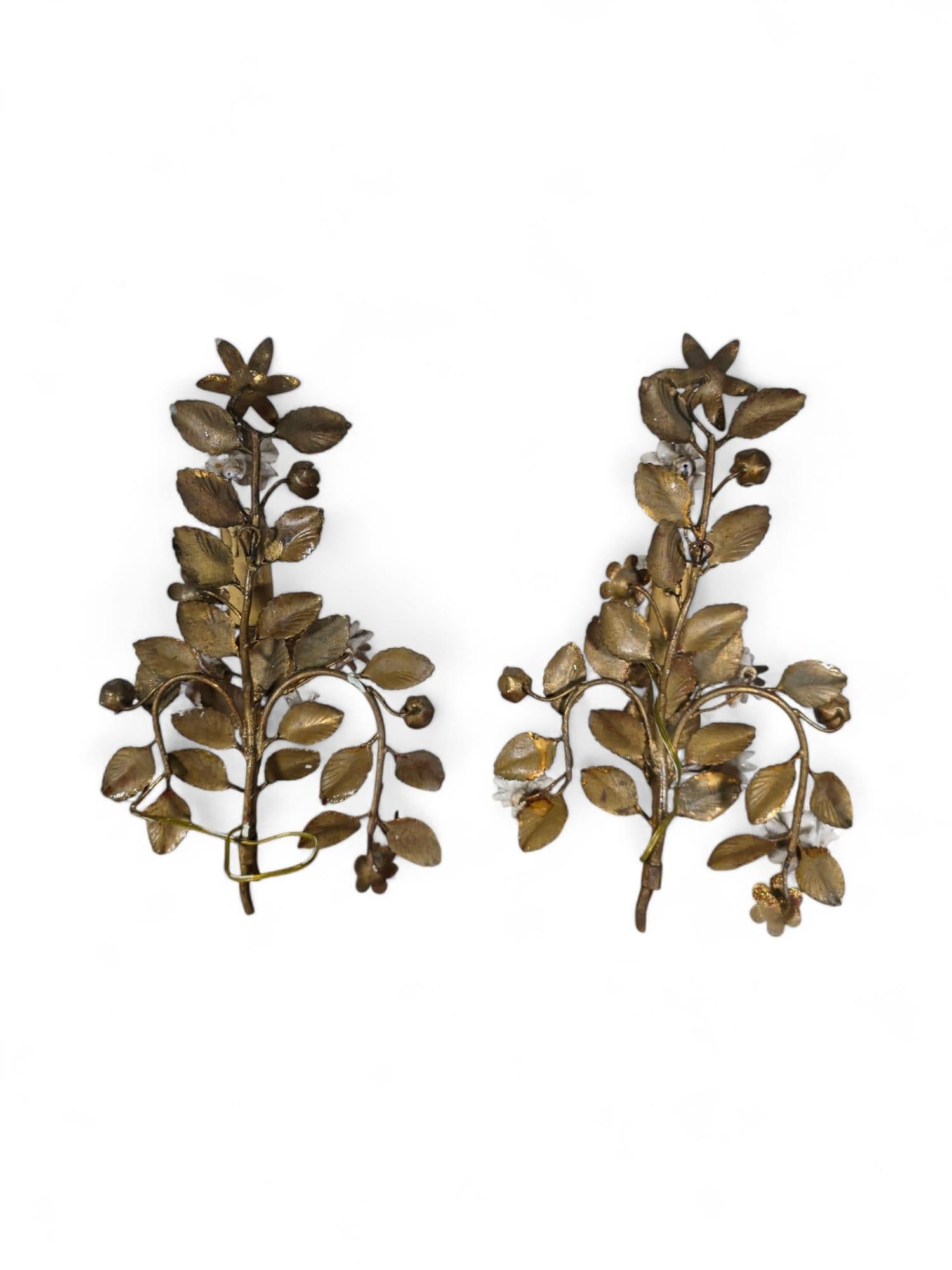 Voici une superbe paire d'élégantes appliques murales françaises des années 1950, magnifiquement travaillées en métal doré et ornées de délicates fleurs en porcelaine. Ces appliques exquises sont non seulement un témoignage du design du milieu du
