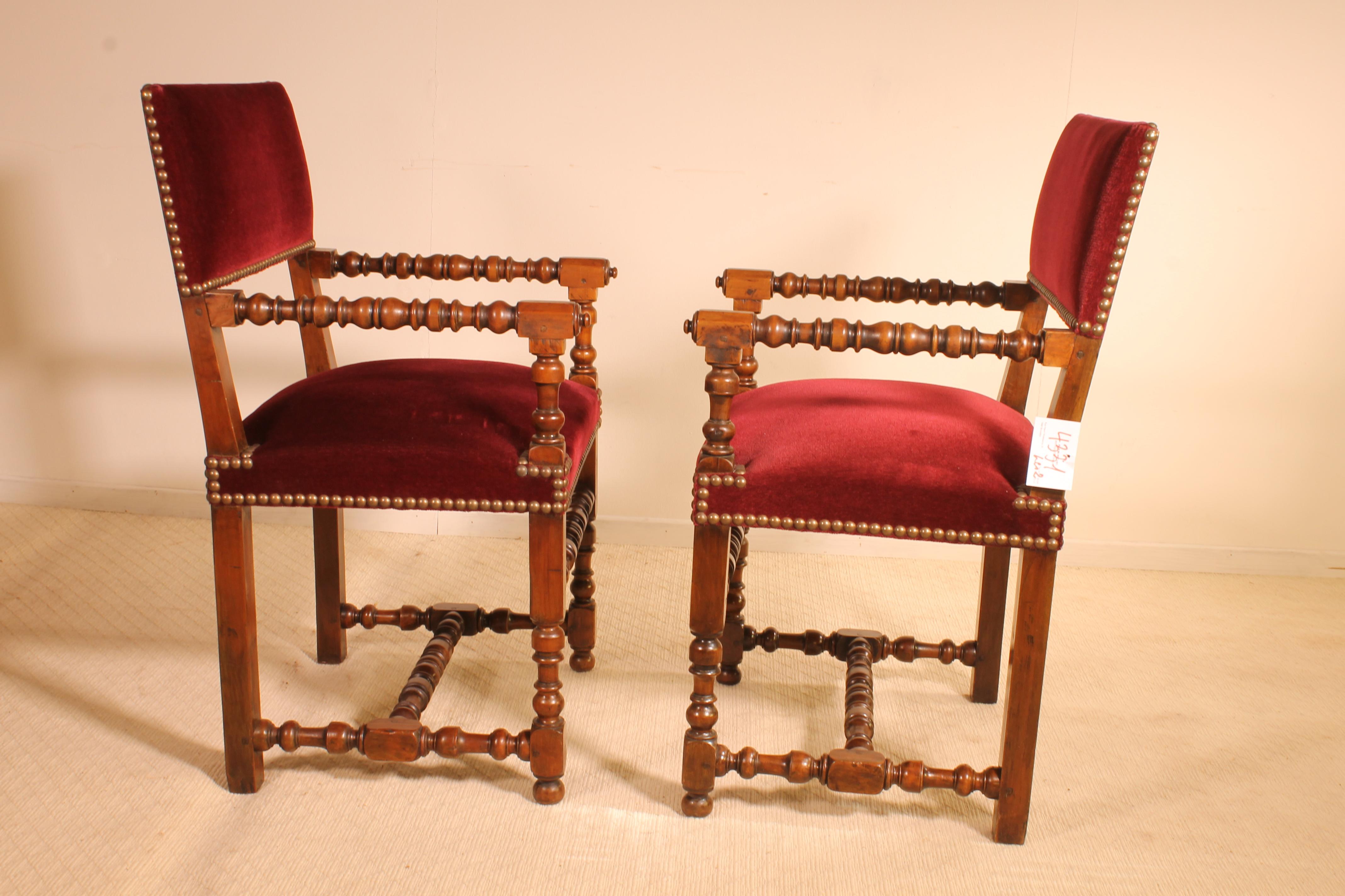 A fine pair of French armchairs in walnut Louis XIII style 19 century. 

This beautiful pair has elegant turned arms and legs and a H-form base. 

This fin pair was re-upholstered with a Beautiful red velvet 
In overall good condition and