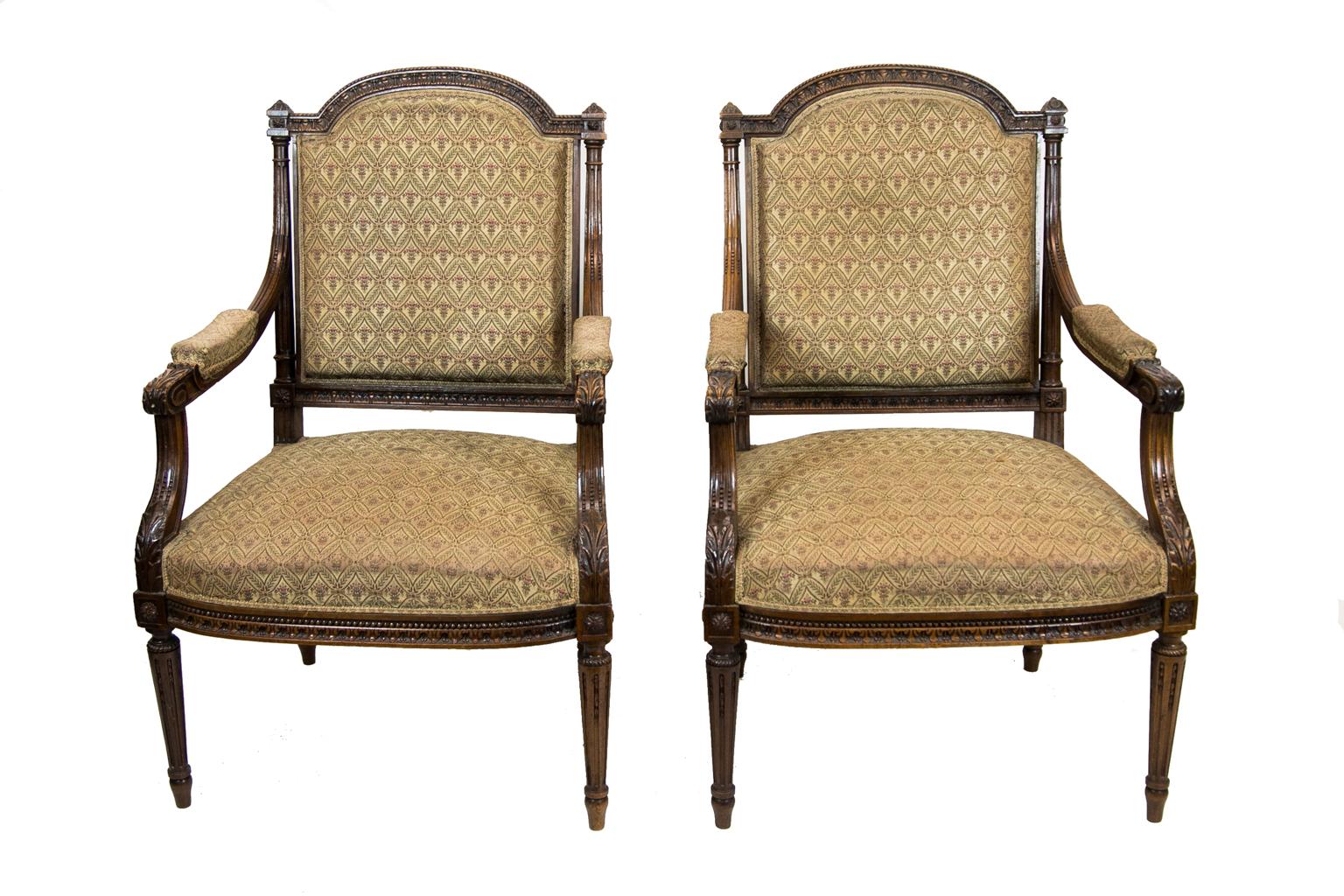 Pair of French walnut carved armchairs, the crest rails are carved with spiral rope carving above a leaf and berry carving. The arms are stop fluted and terminate in carved acanthus leaves.
** the tips of the arm upholstery have worn through.
  