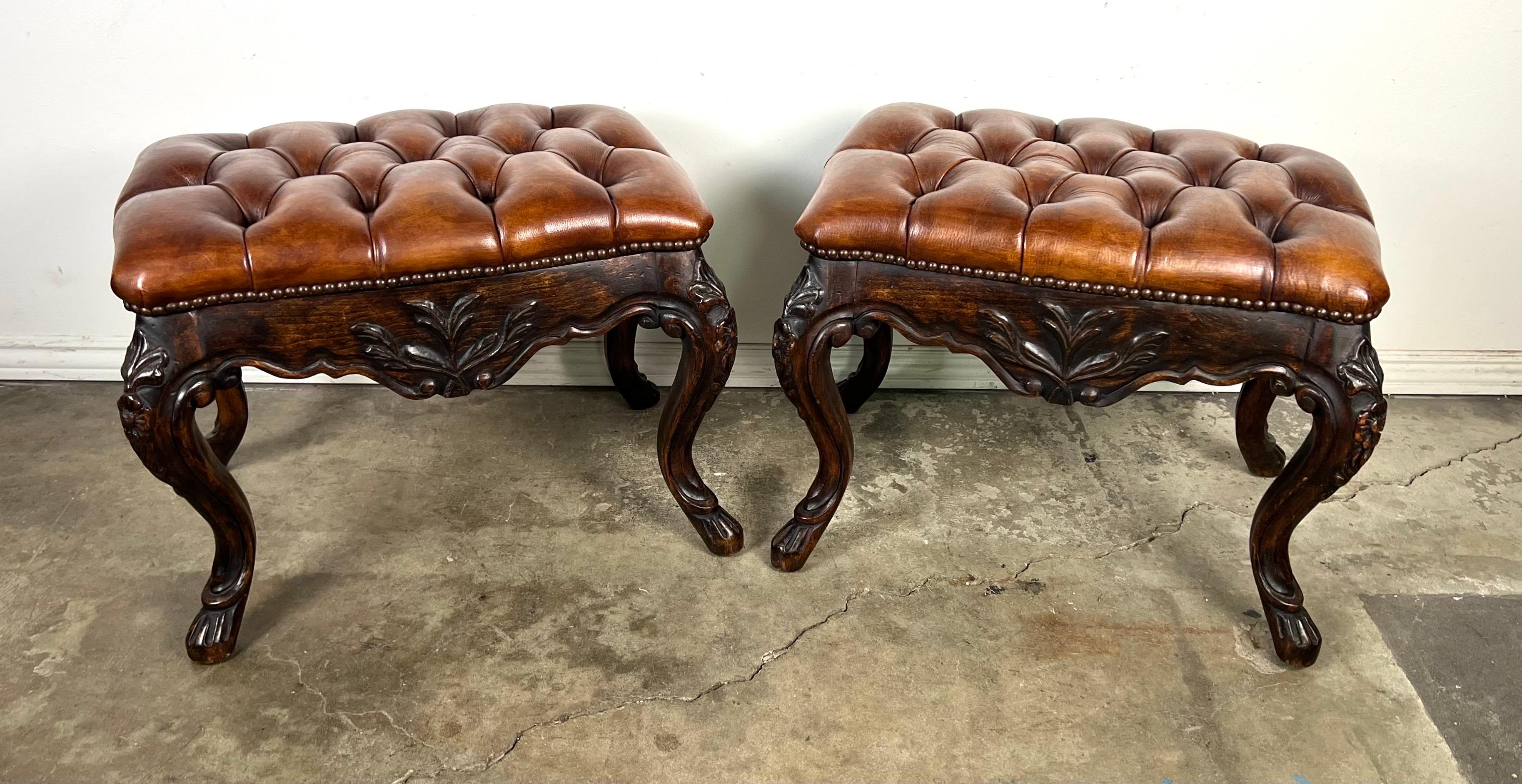Coppia di panche francesi in stile Luigi XV.  Le panche sono caratterizzate da sedute in pelle con inserti in una ricca colorazione marrone.  La pelle è fissata con una fila di decorazioni a forma di testa di chiodo lungo il bordo, che aggiungono un