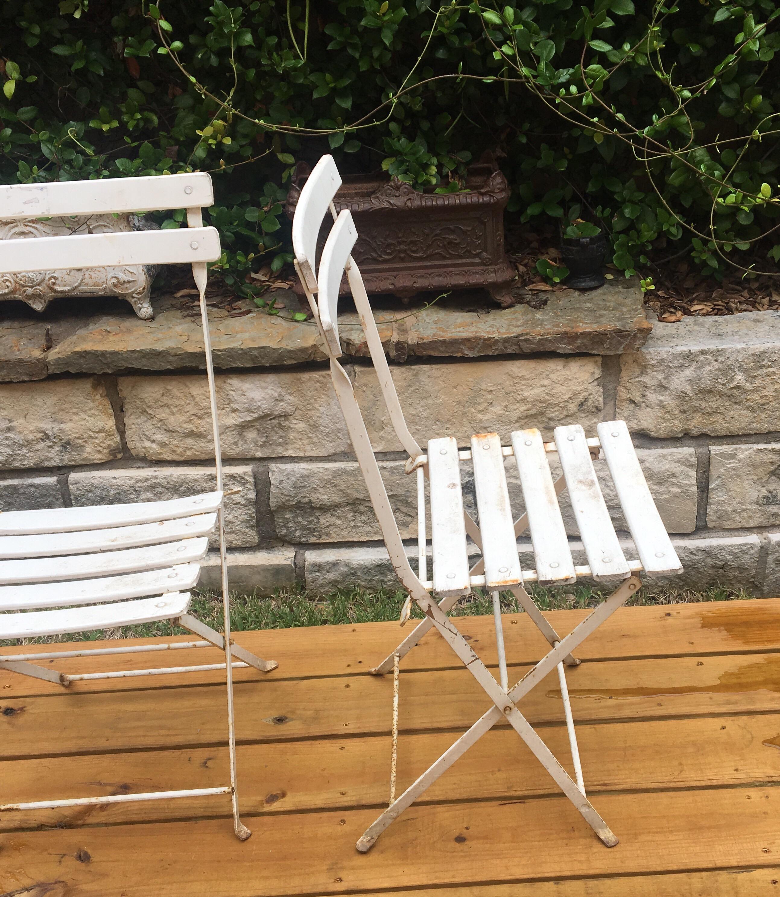 A pair of French white folding chairs.
Dimensions: seat, 19