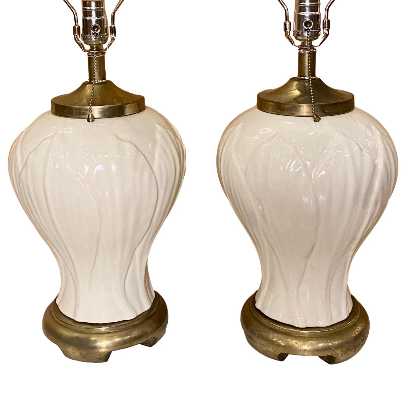 Paire de lampes en porcelaine française des années 1940 avec un motif de feuilles sur le corps et des bases en métal.

Mesures :
Hauteur du corps : 16