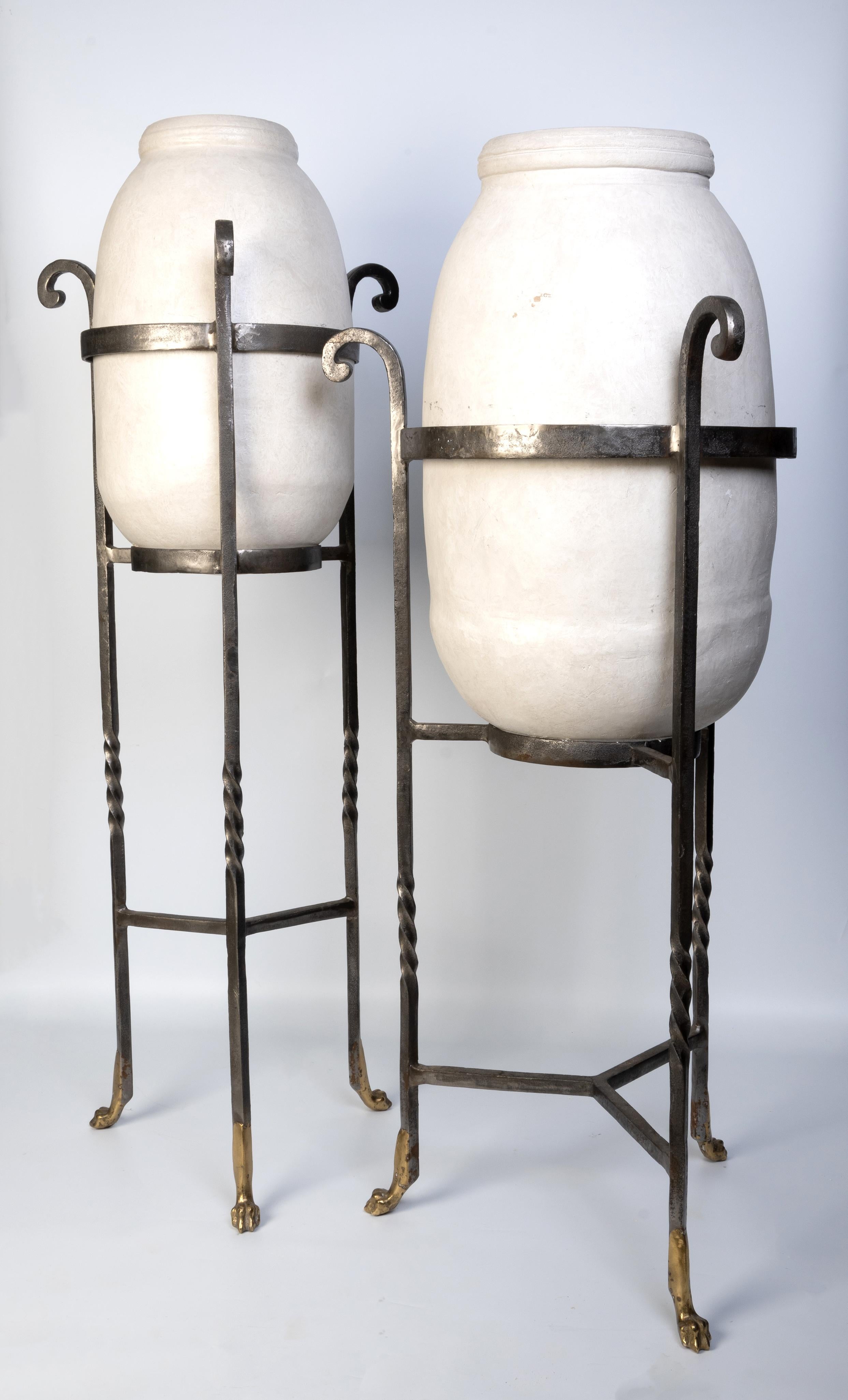 Pareja De Urnas De Cerámica Blanca Montadas Sobre Soportes De Hierro Forjado Terminados En Patas De Latón.
Francia, siglo XX

Dimensiones:
w63 x d70 x h144 cm

w55 x d60 x h153 cm

En muy buen estado. Ligeros arañazos en las urnas de cerámica.