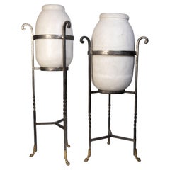 Paire d'urnes françaises en poterie blanche montées sur des supports en fer forgé et en laiton