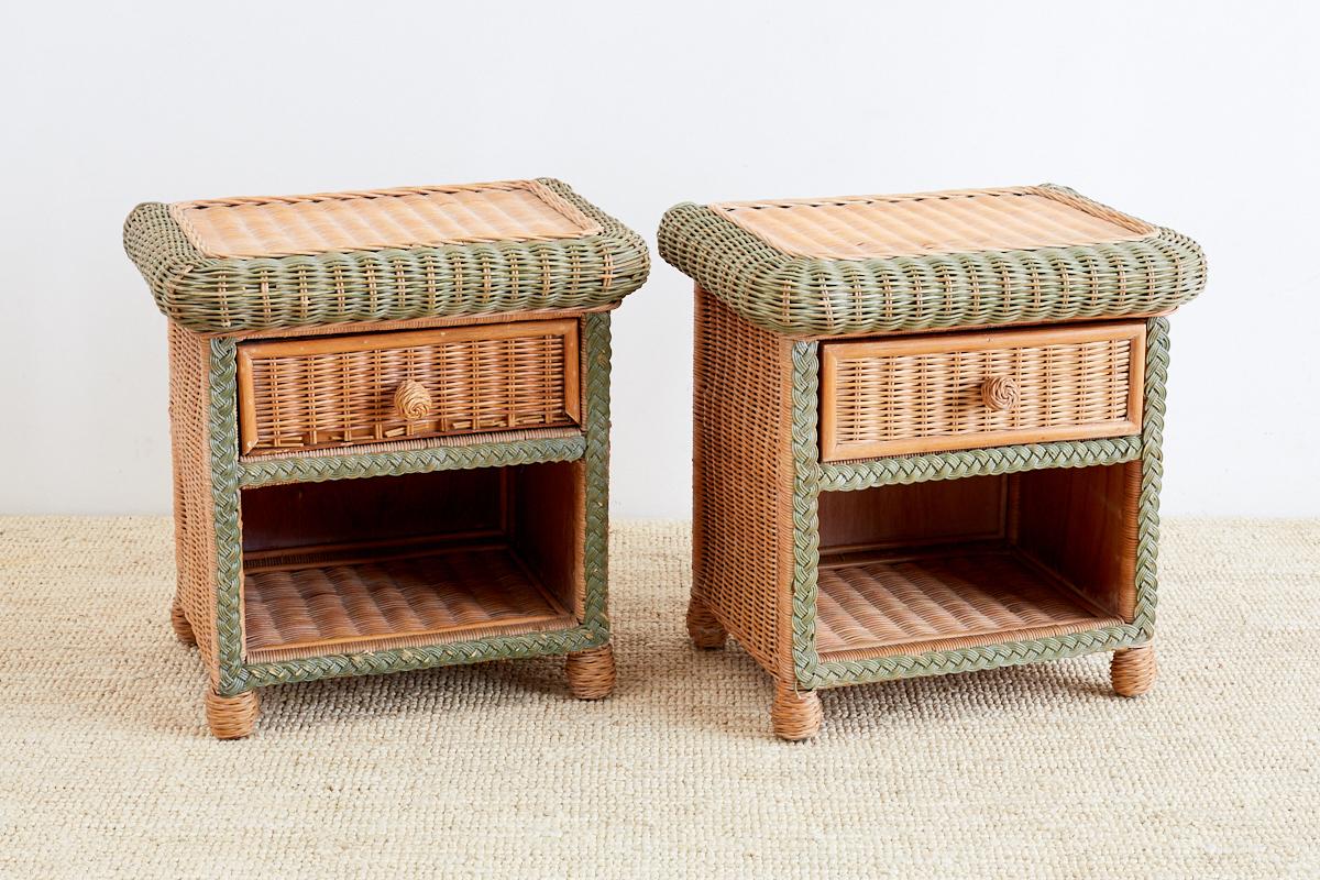 Rustic pair of French wicker nightstands or side tables made in the manner and style of Grange. Wood frames covered in wicker with decorative braided trim. The tables are fronted by a single drawer and an open shelf storage below. Supported by round