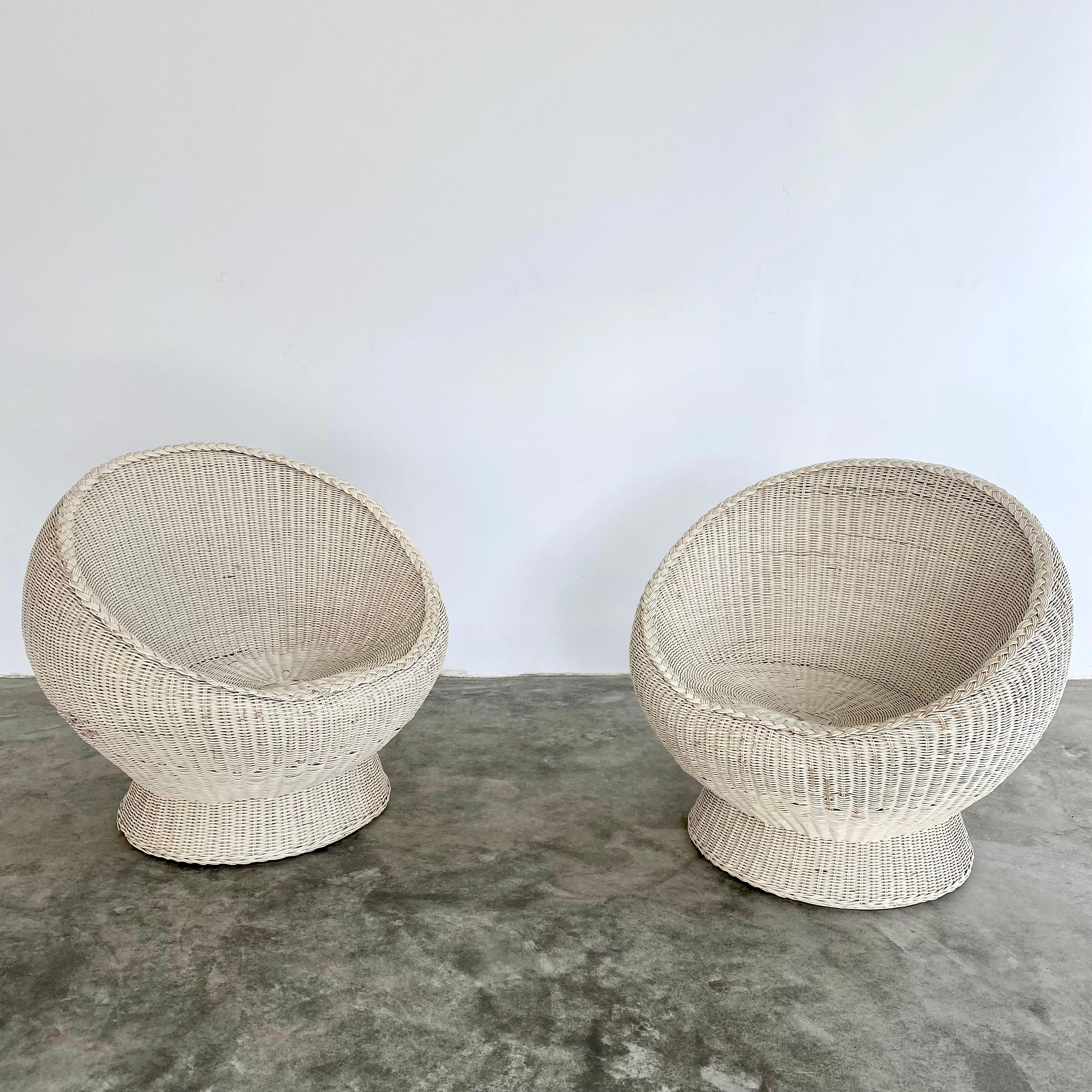 Sculptural pair of French wicker chairs. Circa 1960s. Featuring a woven white wicker frame and braided outline. Great unusual shape. Good vintage condition. Wear as shown.