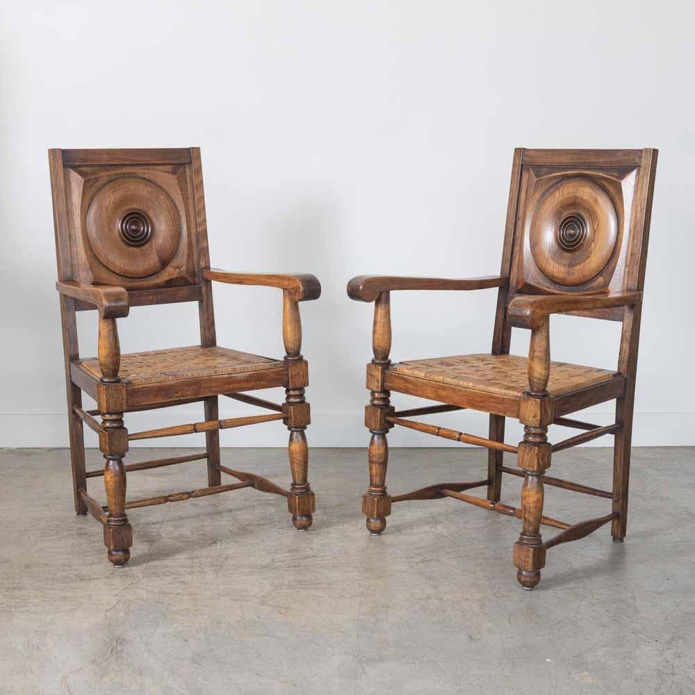 Bellissima coppia di poltrone in legno intagliato di Charles Dudouyt, Francia, anni '40. Splendido dettaglio circolare intagliato sullo schienale in Wood e sulla seduta in rattan intrecciato. Braccioli curvi su struttura in legno massiccio. Sedute