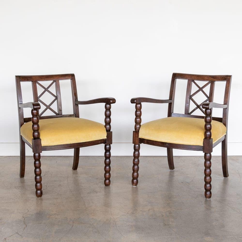 Incredible pair of carved wood armchairs from France, 1940s. Beautiful carved bobbin wood legs and criss-cross detailing on back. Dark stain has been newly refreshed and shows some imperfections with age. Newly upholstered seat in yellow Italian