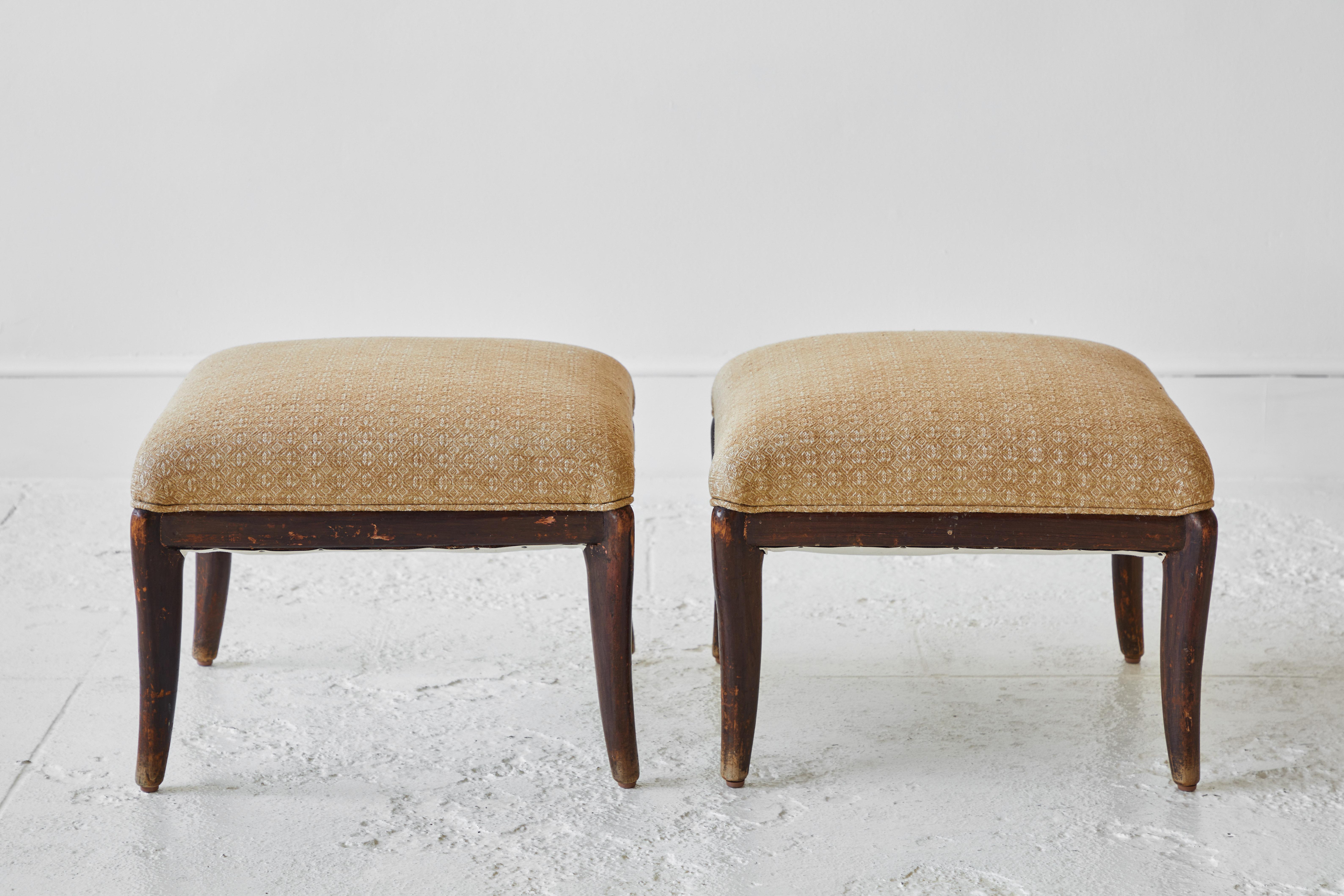 Pair of French wood framed stools newly upholstered in the woven honey colored fabric.