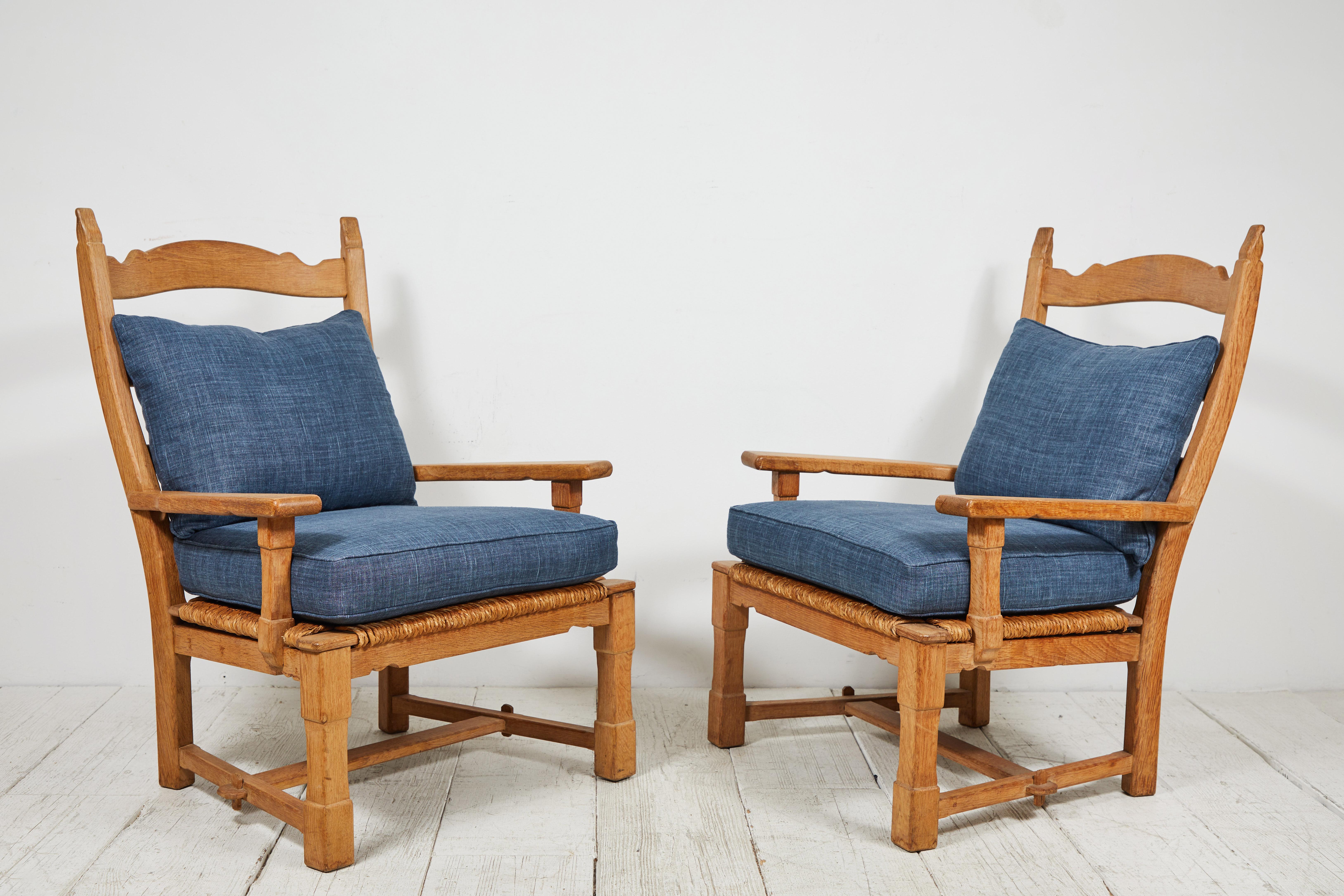 Pair of French wooden ladder back armchairs with rush seat, upholstered in blue linen.