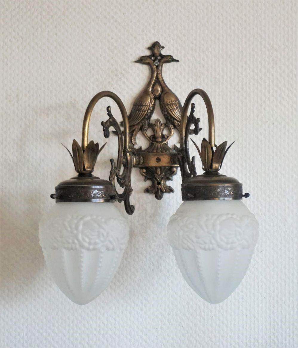A lovely pair of wrought iron birds two-arm wall lights with frosted high relief glass globes, for indoor and outdoor use, France, 1940-1949.
The wall sconces are in very good condition, beautiful aged patina, rewired.
Each sconce takes two E14