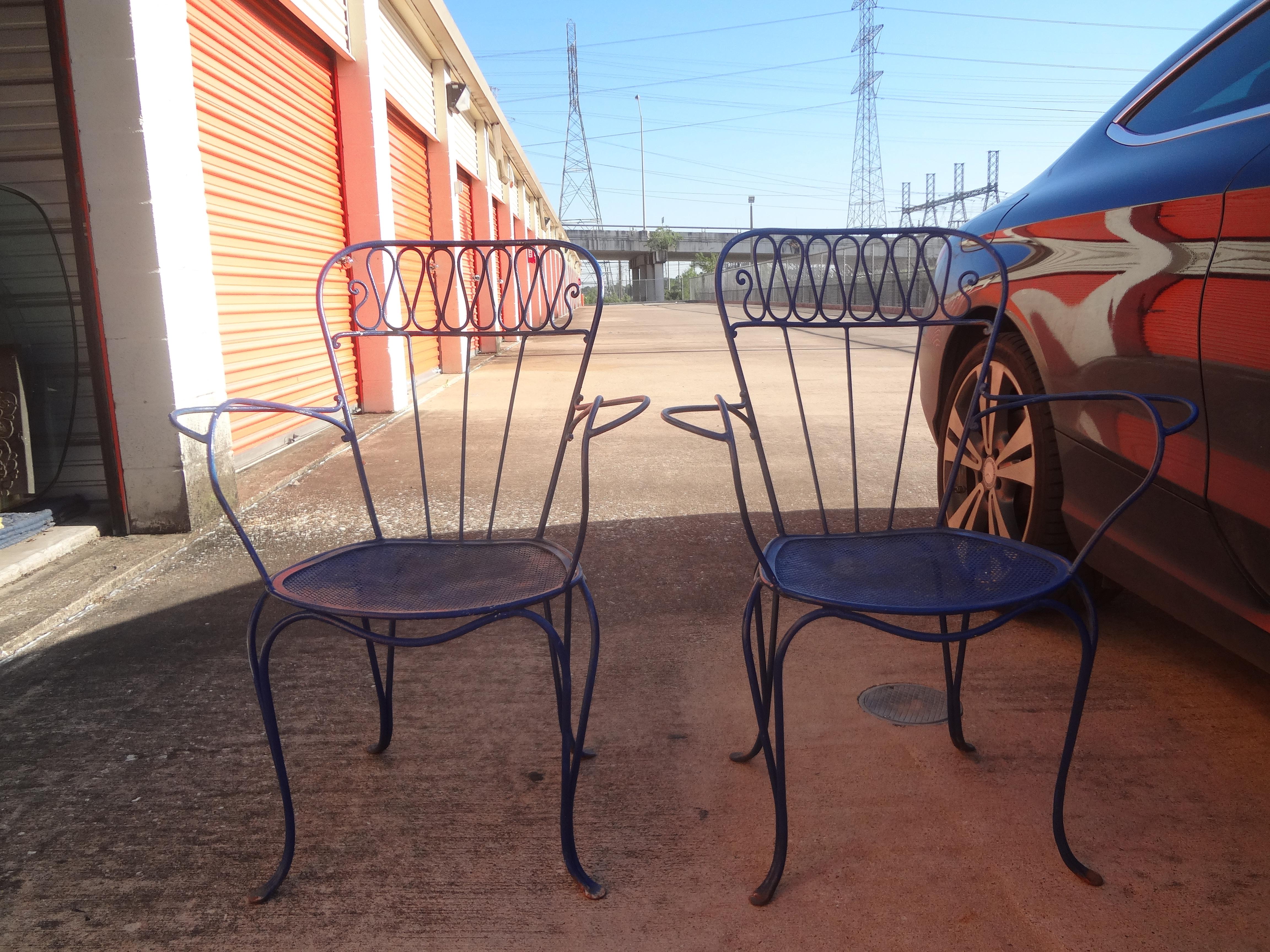 Great pair of antique French wrought iron garden armchairs after Jean Royère. These stylish and comfortable French garden chairs are currently painted a lovely shade of blue. These charming French iron garden chairs date to the 1940s and would look