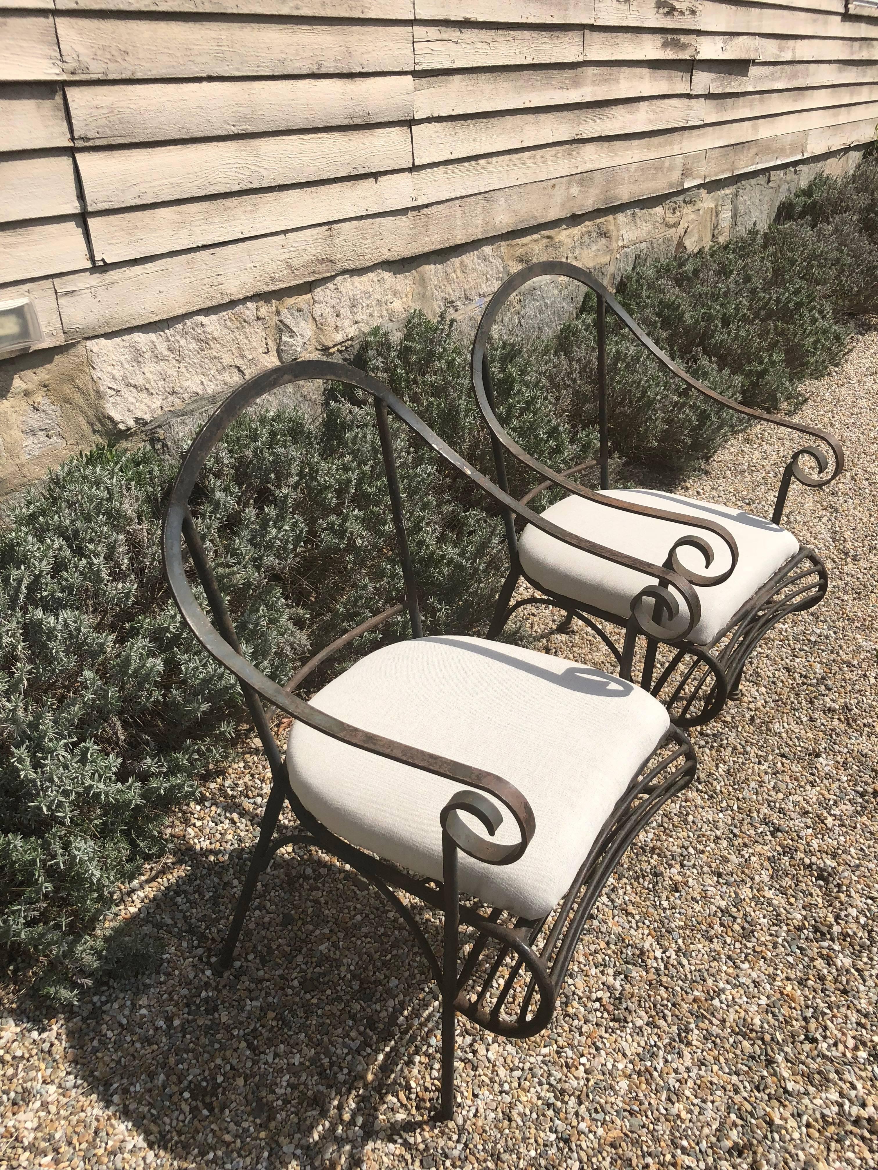 Diese schmiedeeisernen Stühle aus den 1960er Jahren eignen sich perfekt für den Innen- oder Außenbereich und flankieren einen Kaffee- oder Bistrotisch. Mit ihrer schlanken:: geschwungenen Form und den schlüpfrigen Sitzpolstern lassen sie sich leicht