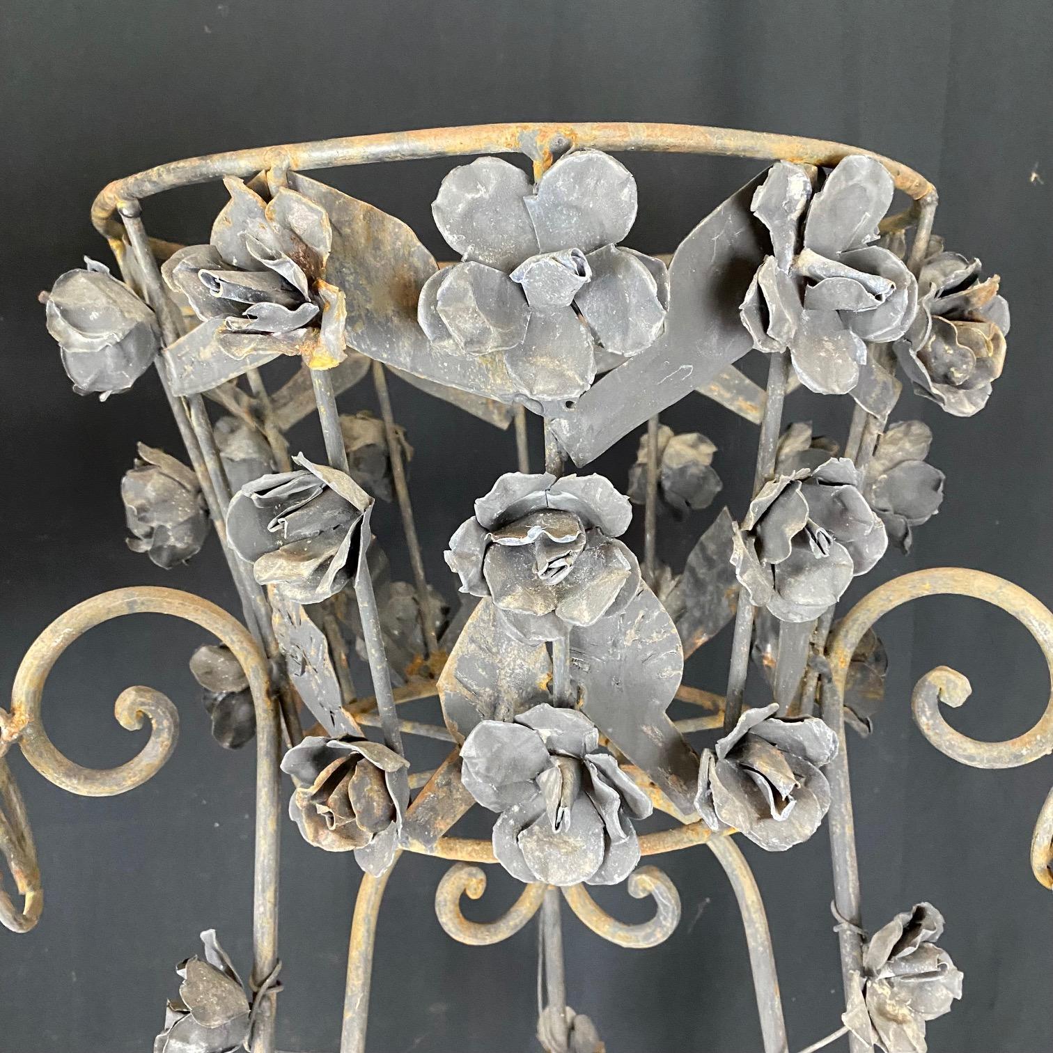 Glorious wrought iron painted pair of jardiniere plant stands having stylized roses and leaves throughout, and pretty weathered patina.  A few flowers are missing on one (see photos), but do not detract from the appearance/is not noticeable. Lovely