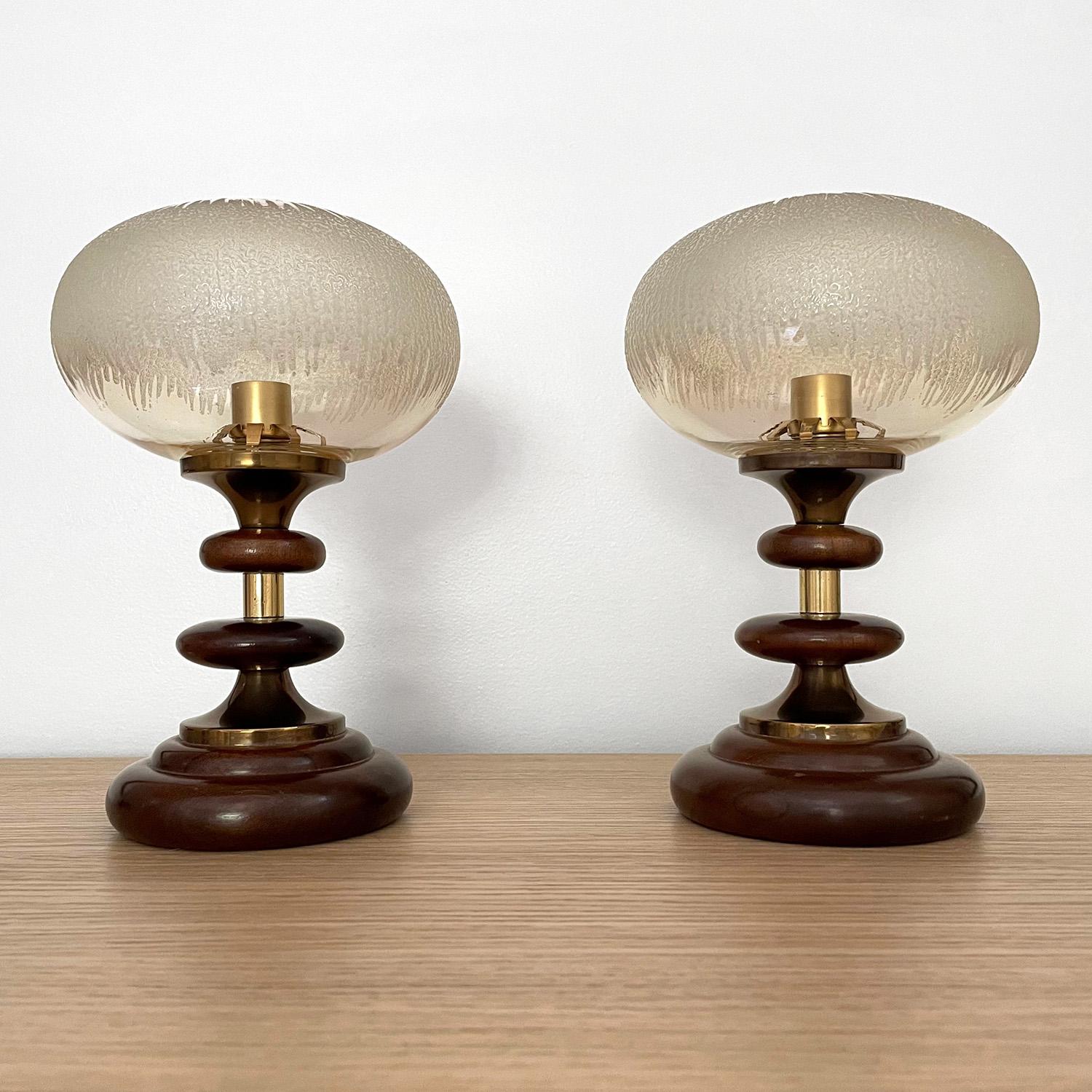 Pair of French tiered wood lamps
France, circa 1960’s
Sculpted bulbous wood discs stacked with brass toned accent pieces 
Frosted textured glass globes beautifully illuminate light
One socket is missing a clip - please reference photos
Patina from
