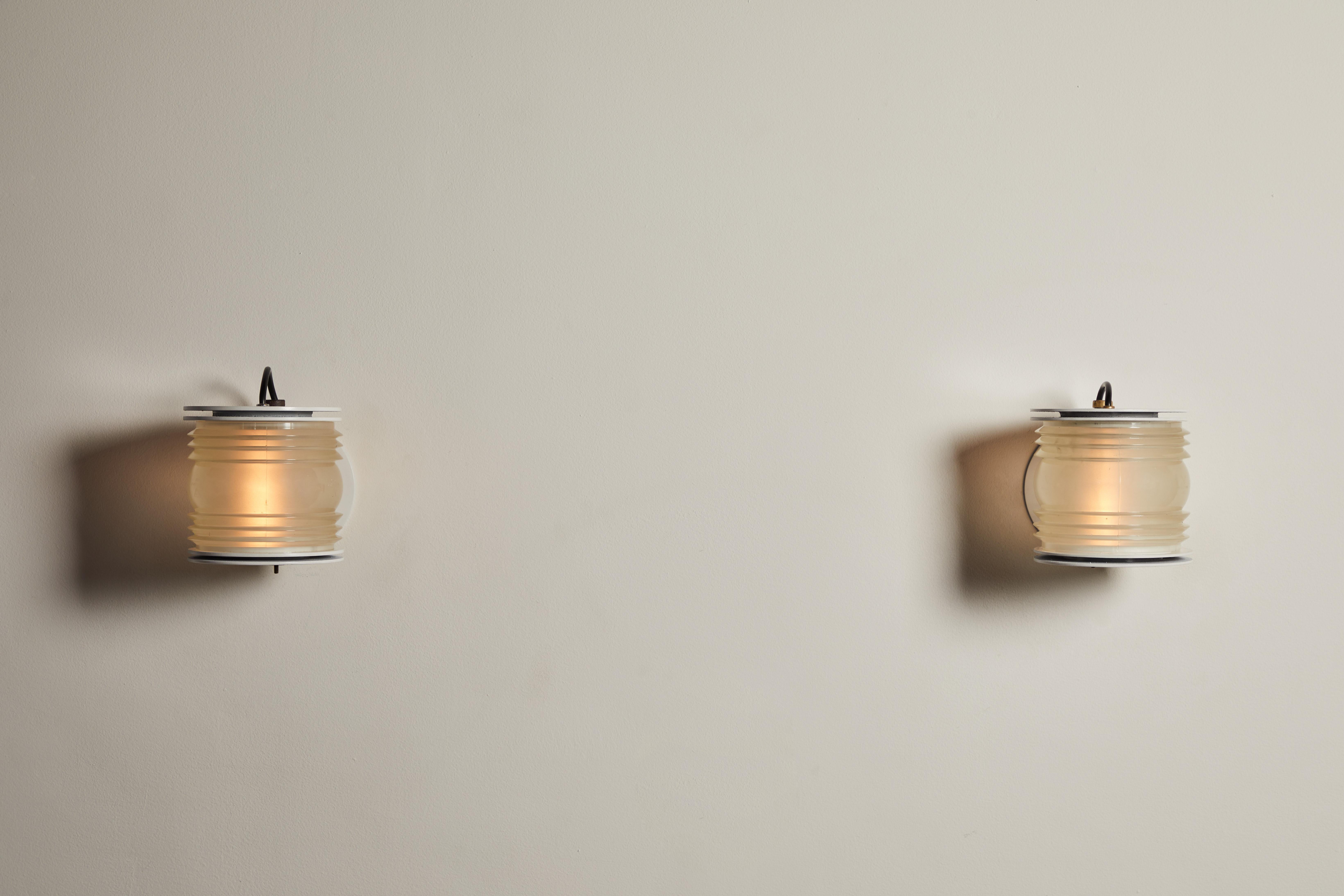Pair of original Fresnel sconces by Joe Colombo for Oluce. Designed and manufactured in Italy, circa 1960s. Enameled metal, textured opaline glass. Rewired for U.S. junction boxes. Each light Takes one E27 100w maximum bulb. Bulbs provided as a one