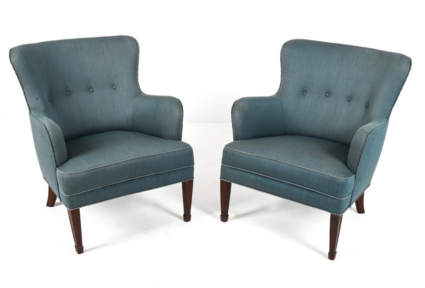 Presenting an exquisite pair of easy chairs produced by the renowned Frits Henningsen in the 1940's. Crafted with sophistication and attention to detail, these armchairs encapsulate the the essence of Danish Modern elegance. 

Solid mahogany legs