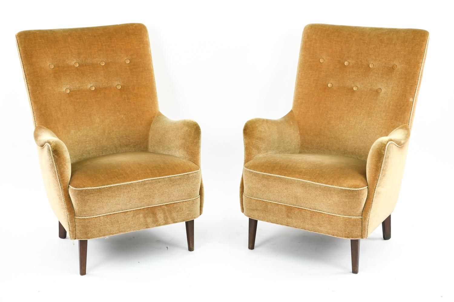 A pair of Danish midcentury lounge chairs in the style of Frits Henningsen. These Scandinavian Modern easy chairs feature rectangular form tufted backs and sleek lines throughout, giving them an attractive appearance from any angle.