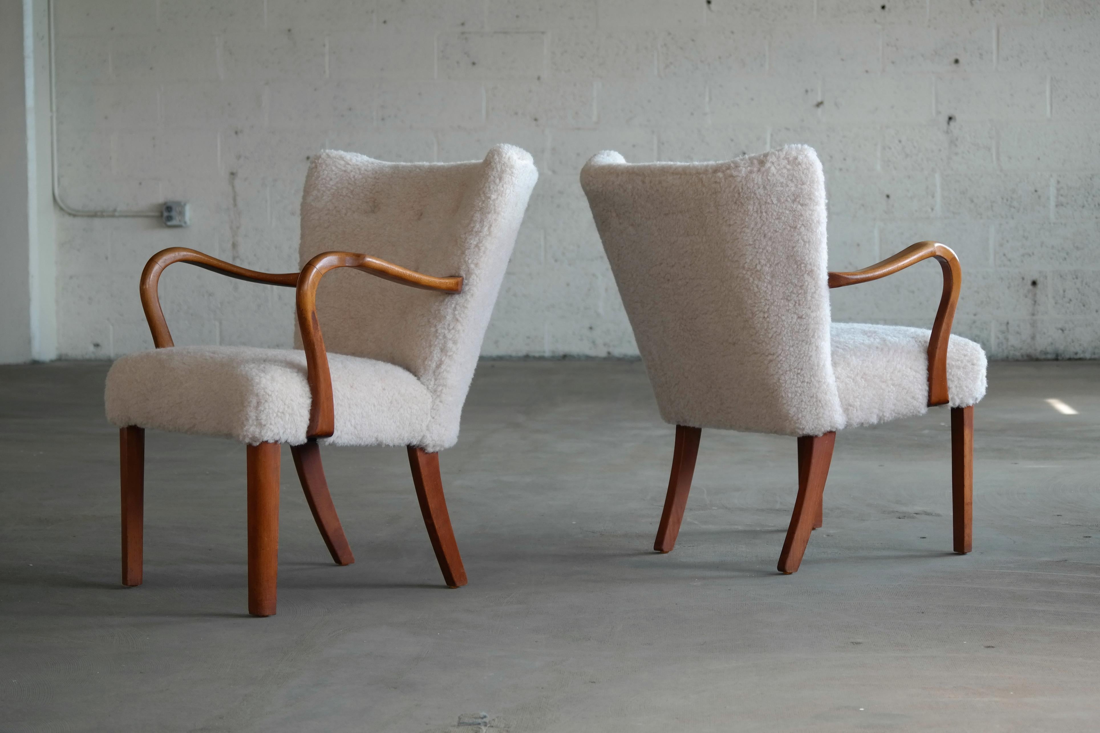 Pair of elegant nice smaller size easy chairs from the late 1940s-1950s very typical of Fritz Hansen's design style both in terms of legs and armrests. Made from stained beechwood with nicely sculpted/carved armrests. Some natural age wear to the