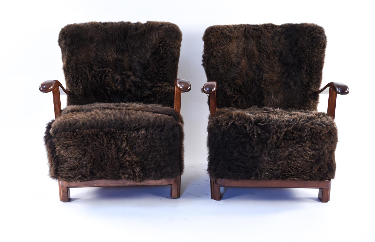 A gorgeous pair of Danish mid-century model 1594 lounge chairs by Fritz Hansen. A highly sought after design which has been upholstered in rich, brown lamb's wool. Incredibly soft and comfortable, these chairs provide a perfect place to relax with