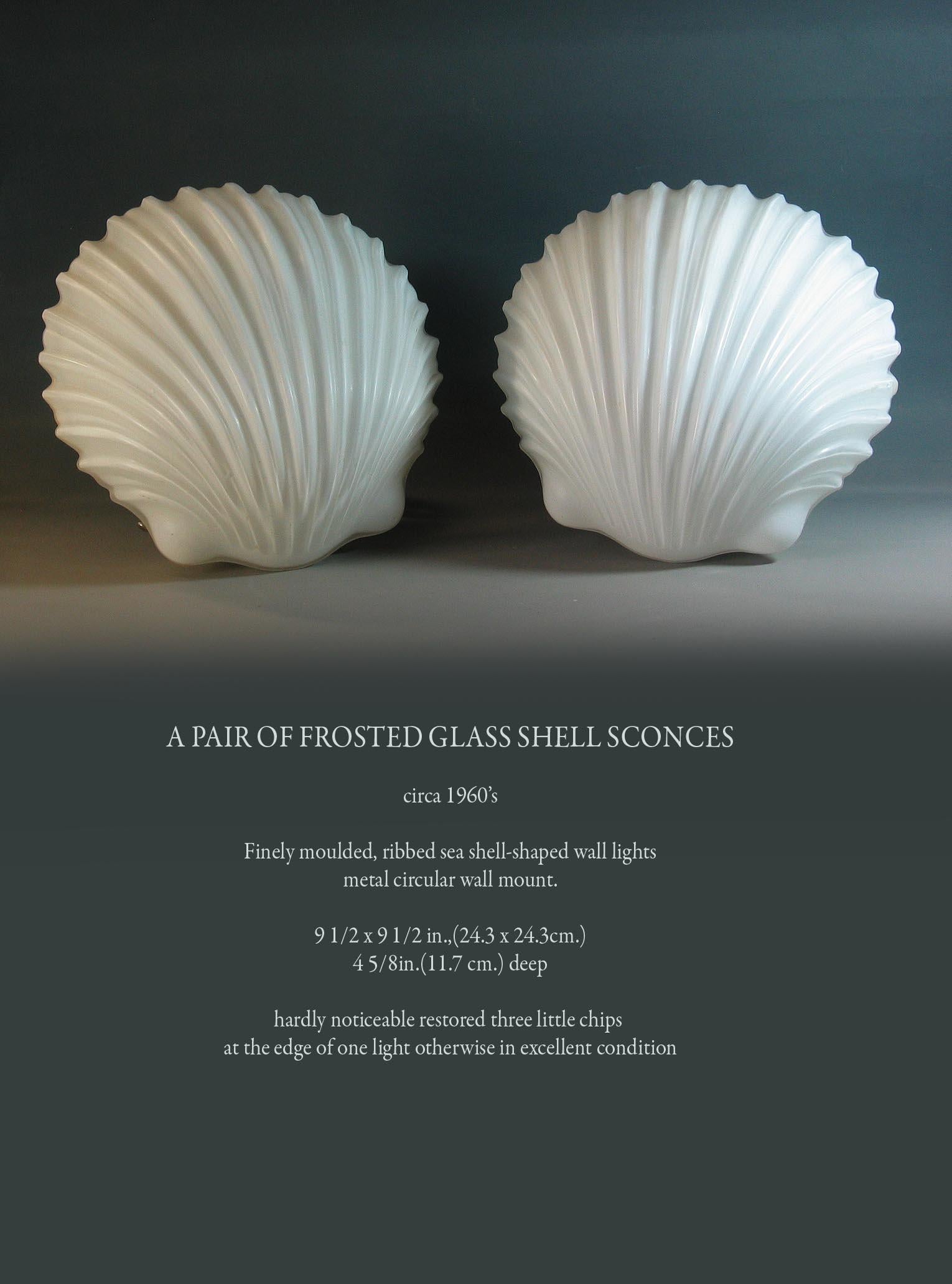 A pair of frosted glass shell wall sconces,
circa 1960s.

Finely moulded, ribbed sea shell-shaped wall lights
metal circular wall mount.

Measures: 9 1/2 x 9 1/2 in., (24.3 x 24.3 cm.)
4 5/8in. (11.7 cm.) deep.

Hardly noticeable restored three