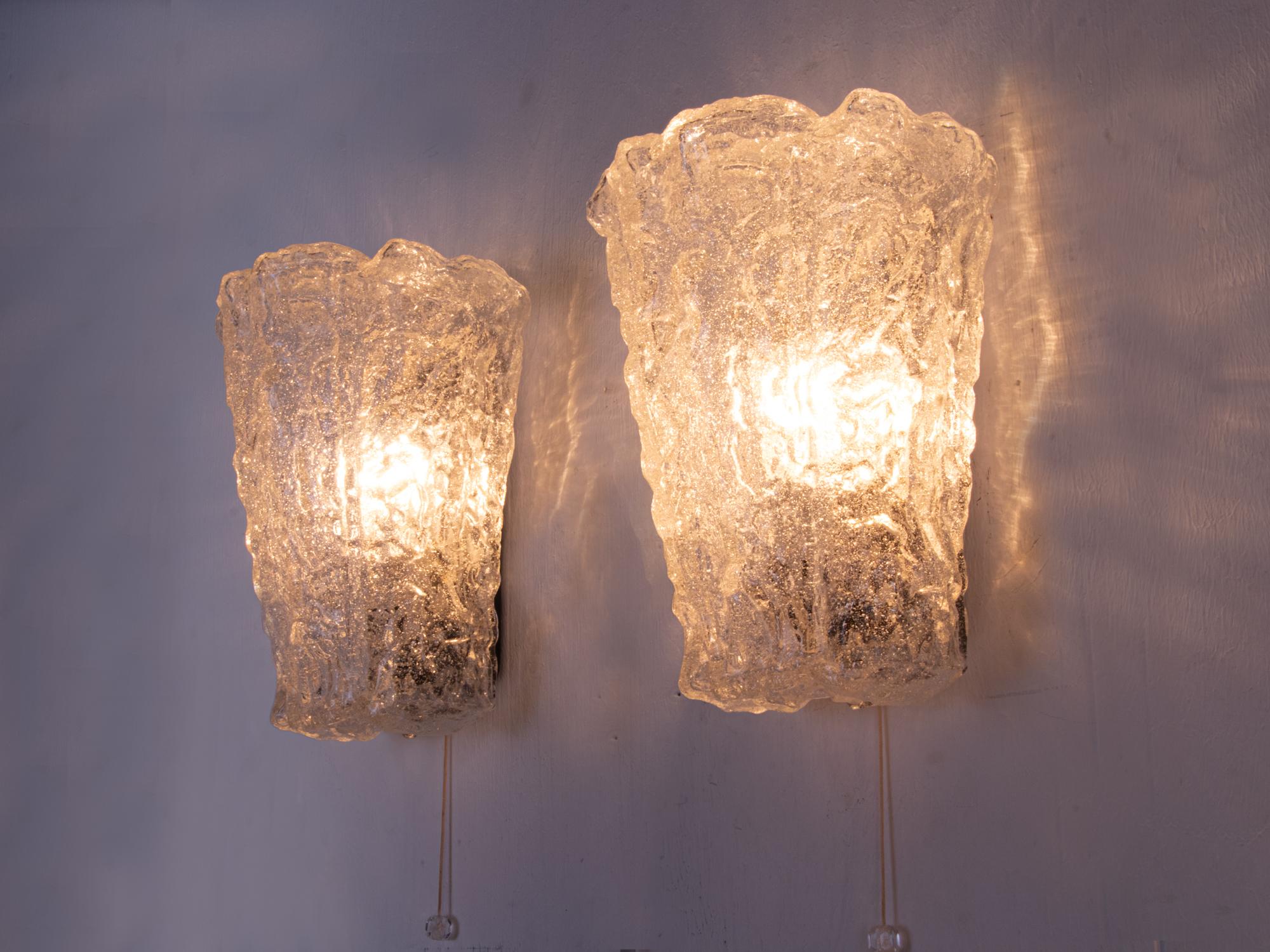 Stunning pair of vintage wall sconces with thick, frosted Murano ice glass shades on a metal frame. These Murano lamps cast warm, indirect light into your modern home and offer a variety of possibilities. For example, they can be placed next to a