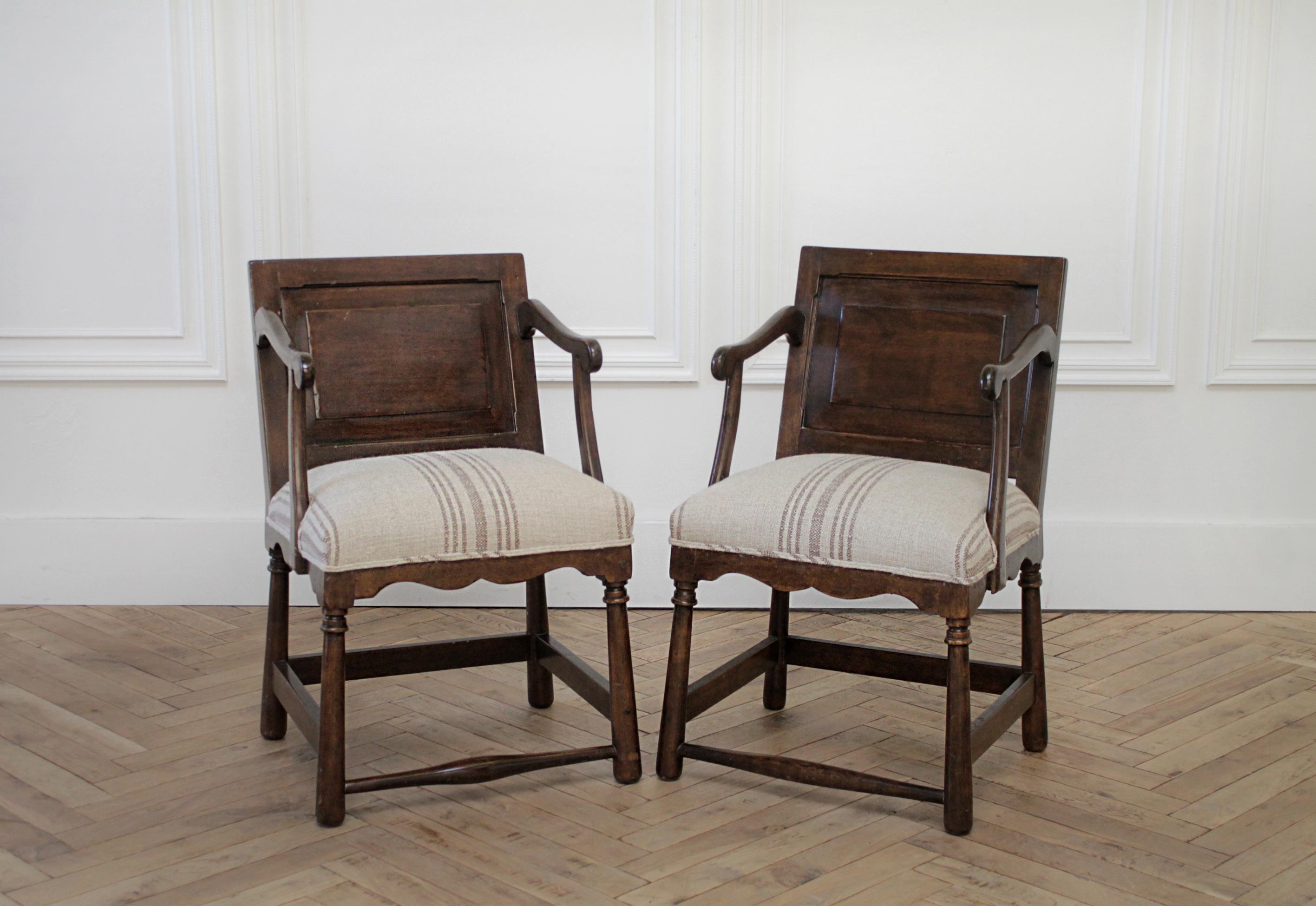 Pair of fruitwood carved and upholstered armchairs
Dark colored wood with natural patina, upholstered in a light natural colored grain sack fabric with brown stripe.
Measures: 19.5