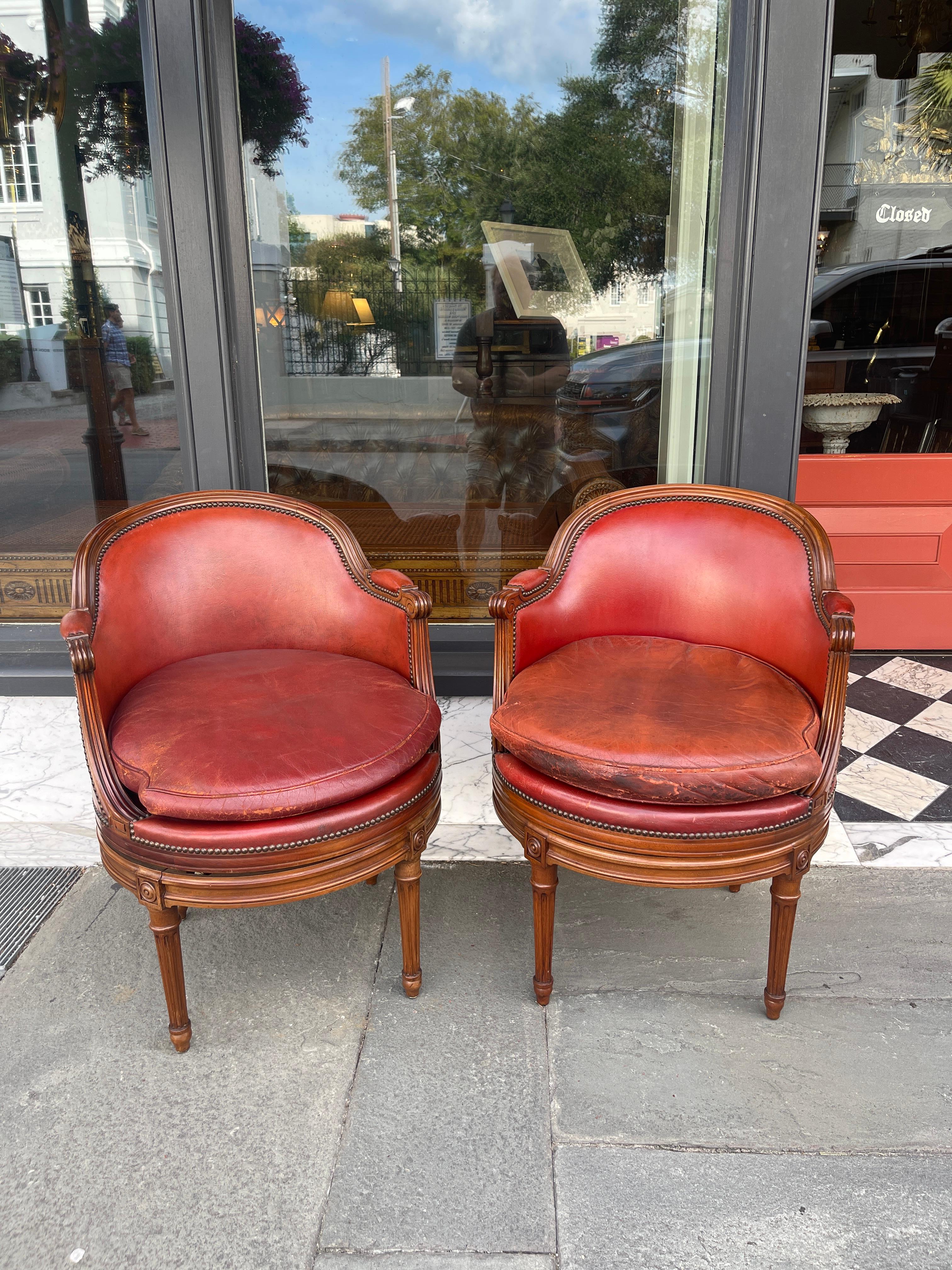 Leather Pair of fruitwood swivel chairs in ox blood leather with Gouffe label