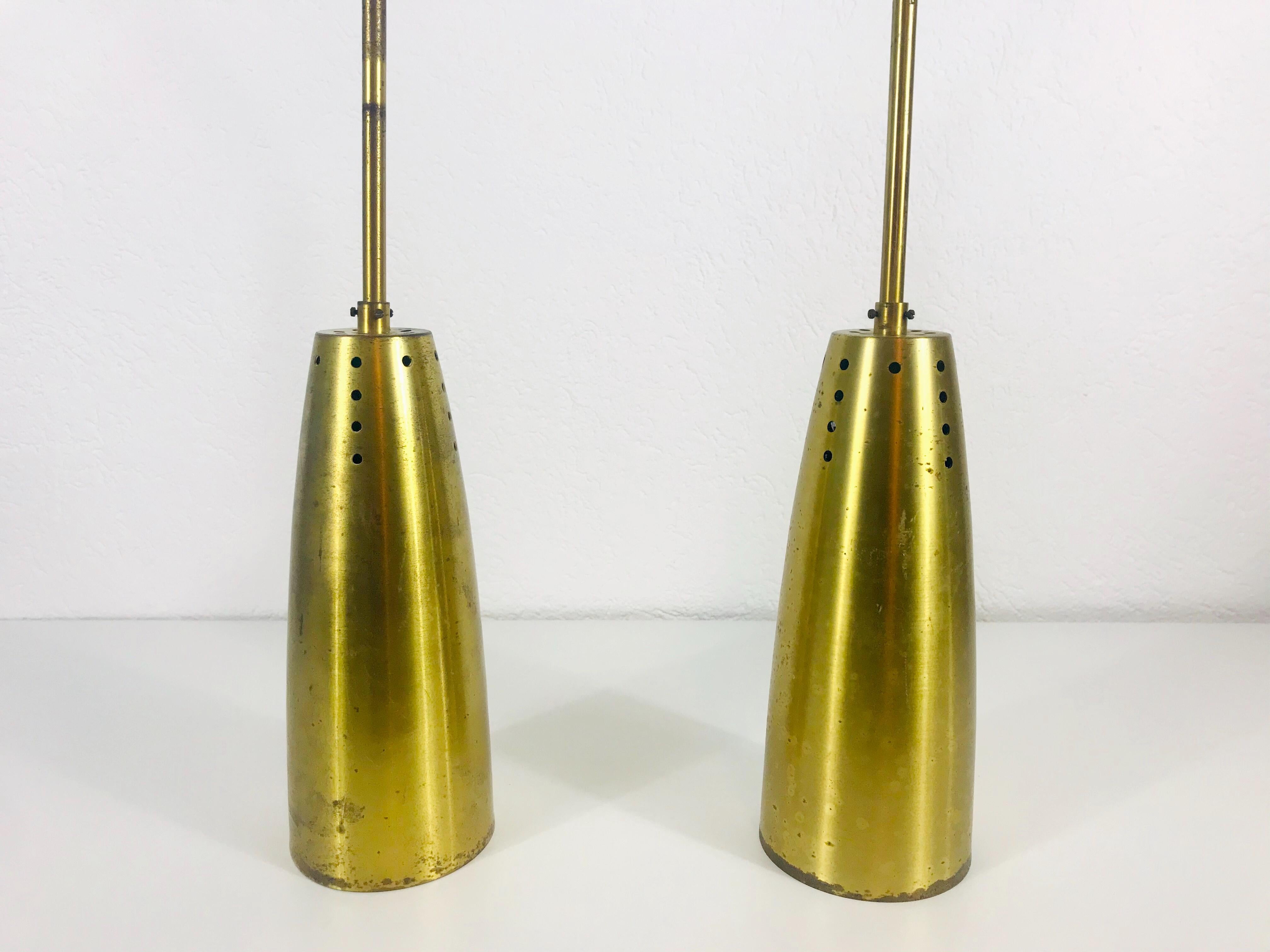 Pair of very rare pendant lamps made in Germany in the 1950s. The lighting is made of brass and has the style of the Italian brand Stilnovo. It has many small holes which are creating beautiful light. The lighting requires one E27 light