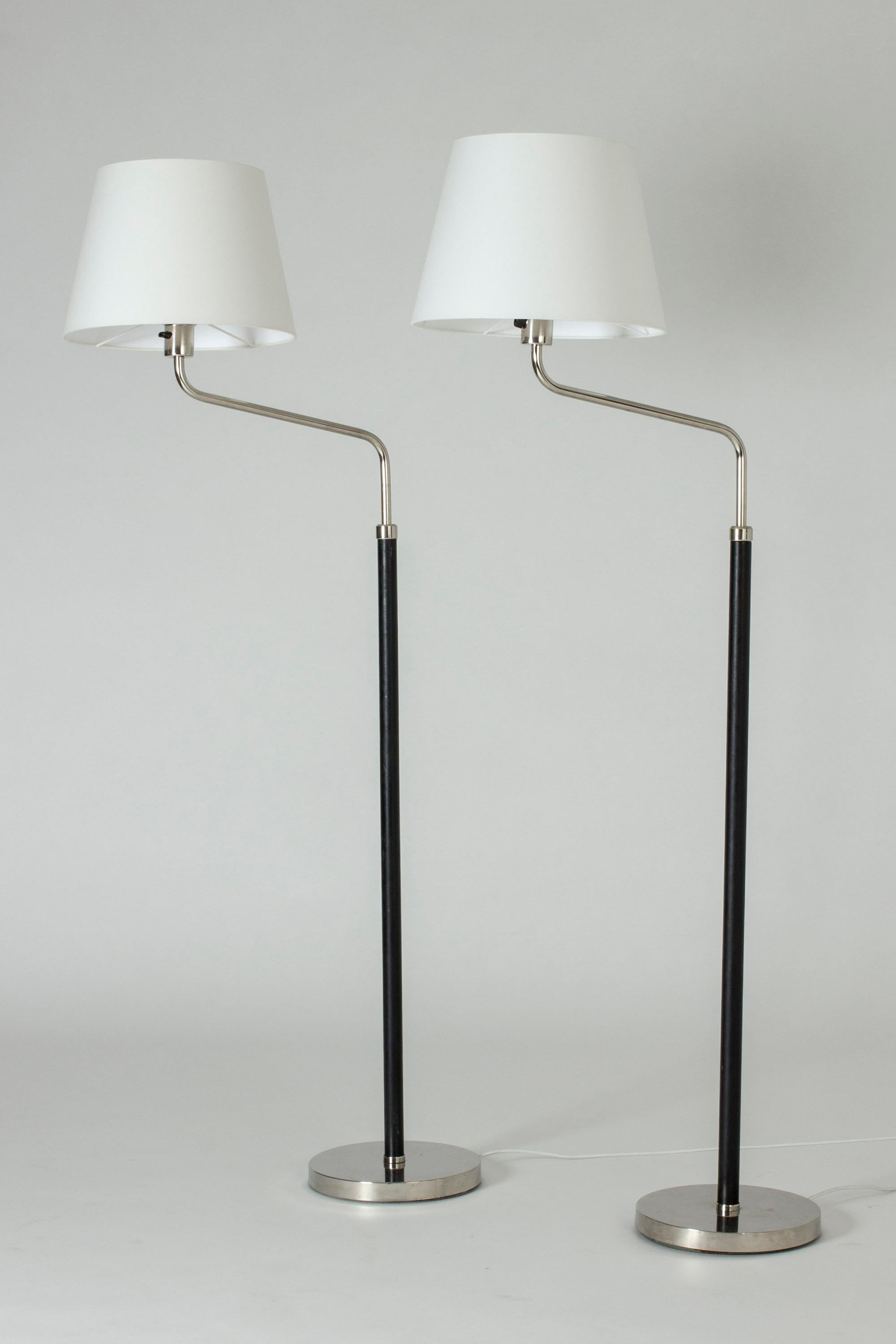 Ein Paar kühle funktionalistische Stehlampen von Bertil Brisborg. Hergestellt aus Stahl mit lederbezogenen Stangen.