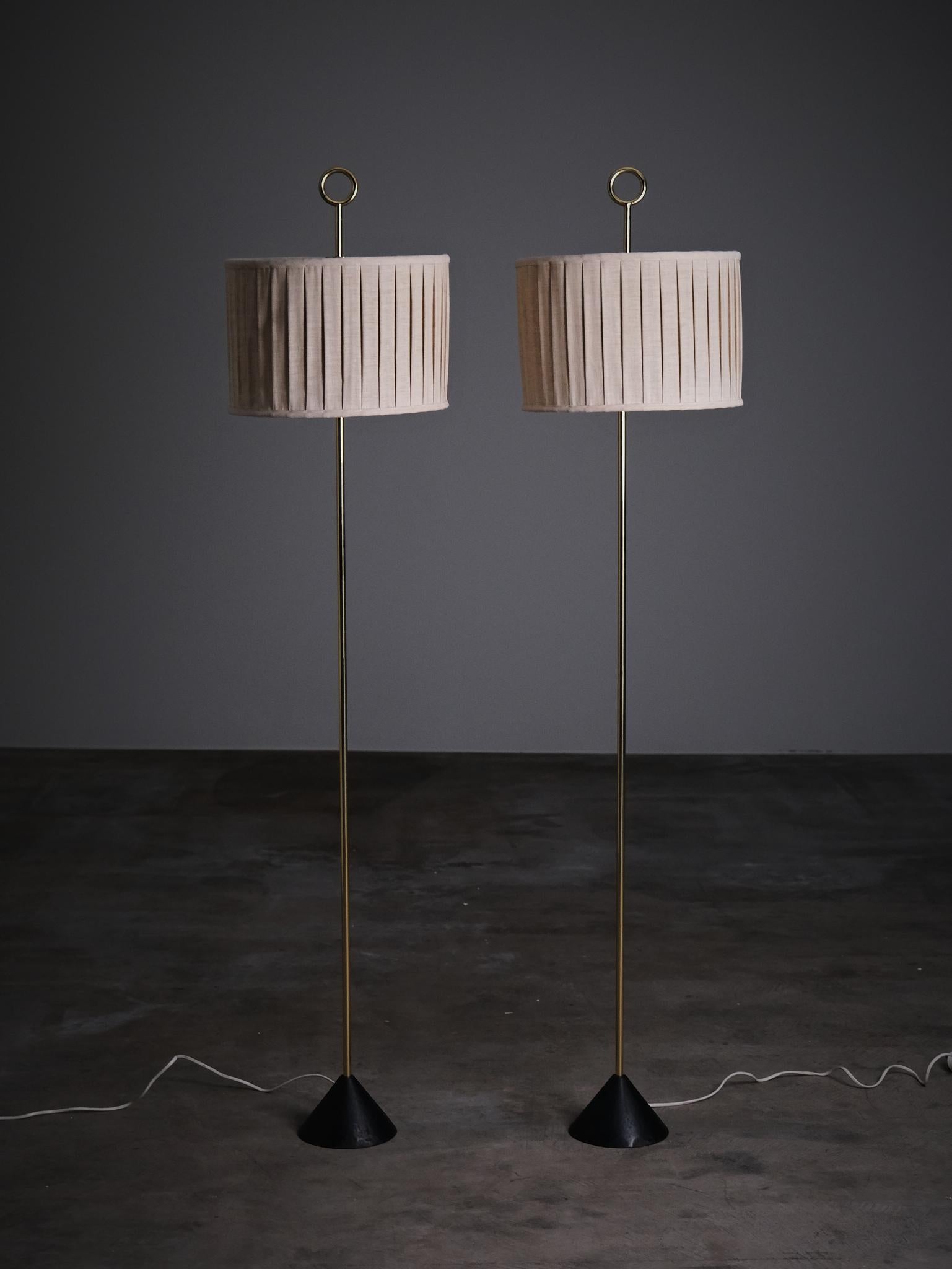 Rare pair of floor lamps model 'G-20' designed by Hans-Agne Jakobsson for his own company Hans-Agne Jakobsson AB in Sweden during the 1950s. 

Made with a beautiful, thin, brass pole, mounted on a cast iron foot. Shade with pleated fabric. On the