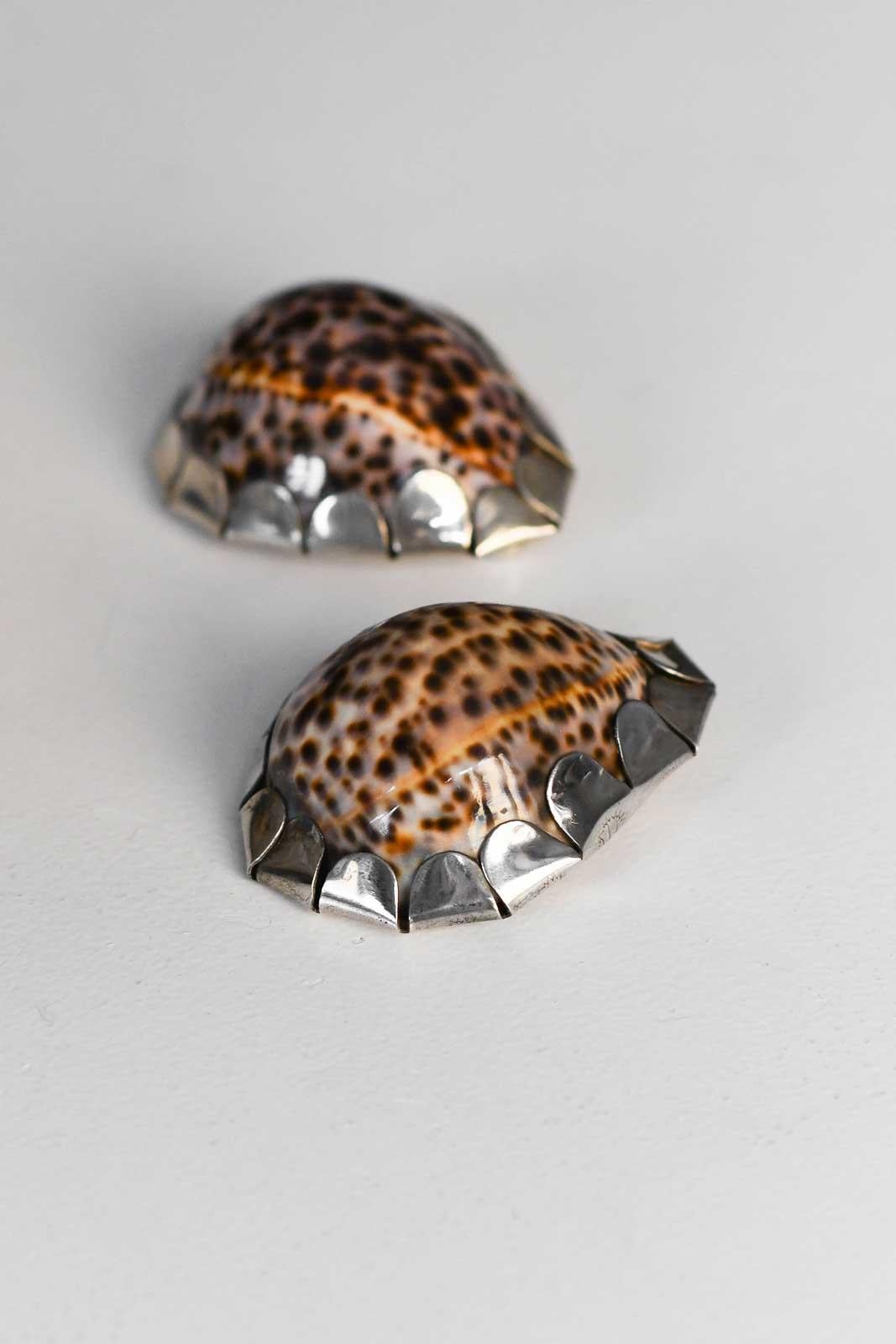 Paire de coquillages Gabriella Crespi avec application de métal argenté décoré à la main, signature gravée, années 1970.
Détails du produit
Dimensions : 8 L x 3.5 H x 6 D cm

